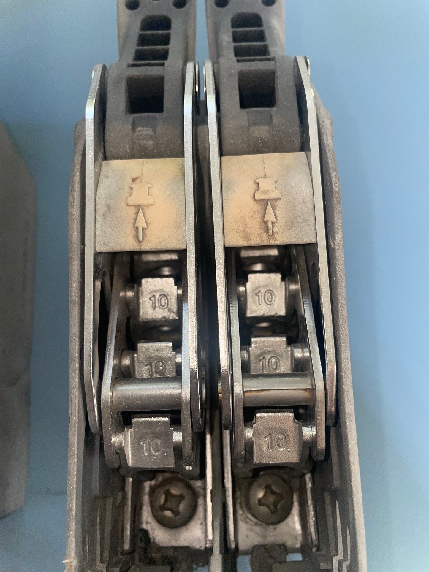 Close-up of a metal tool with multiple components on a blue background