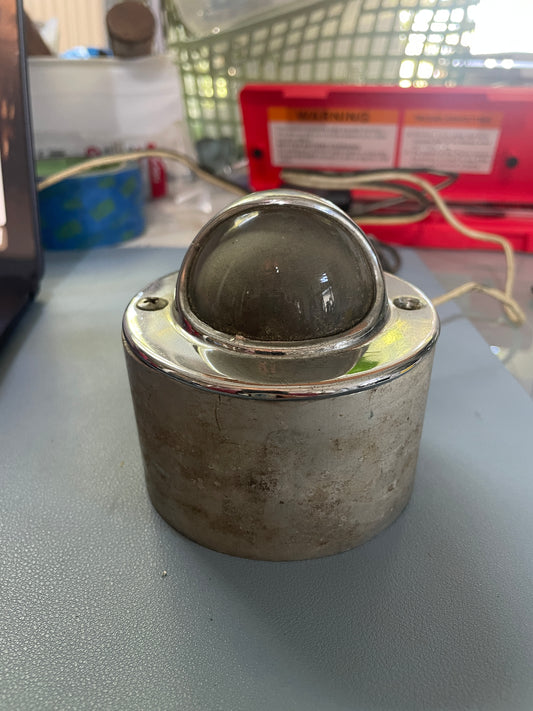 Metallic cylindrical object on a gray surface with a blurred background