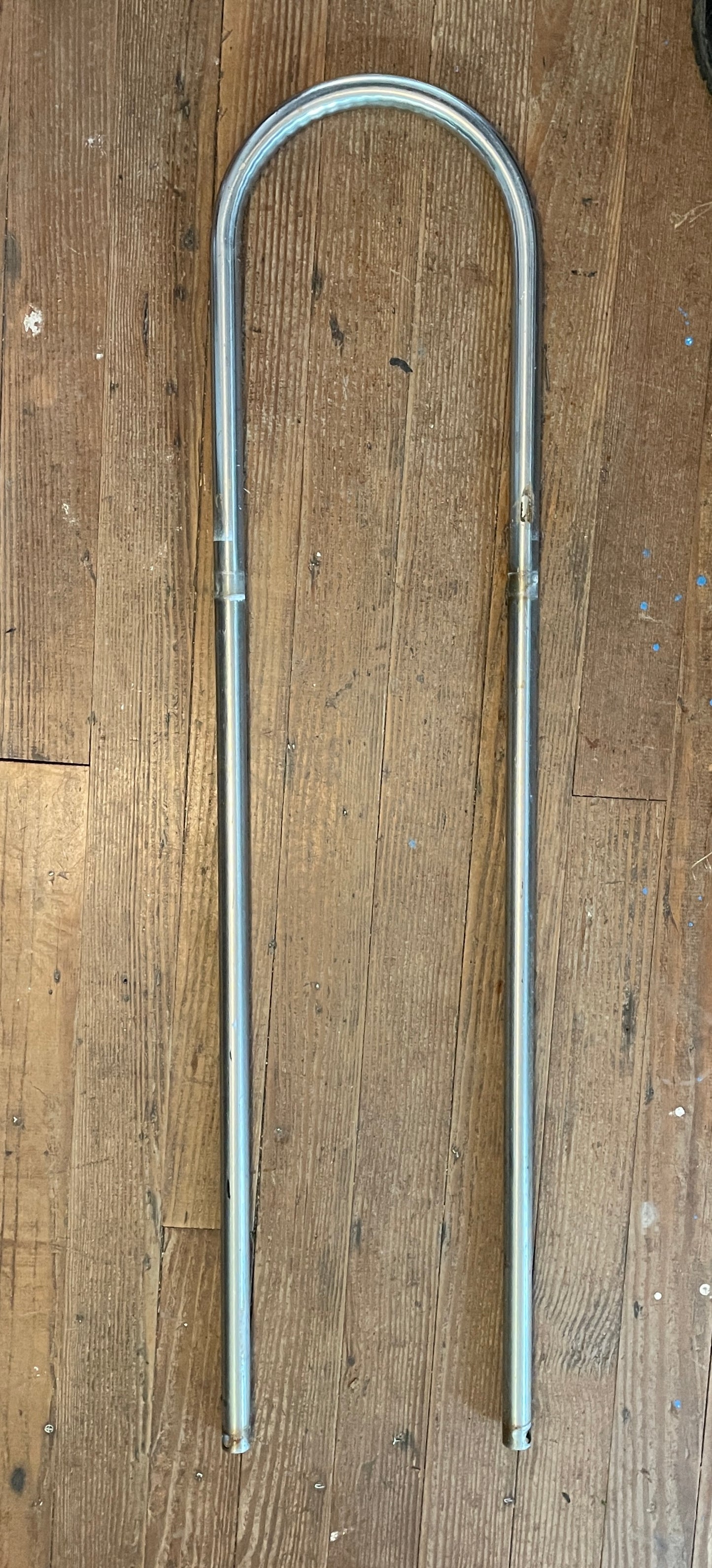 A stainless steel pedestal guard with 1/18 inch tubing, standing 40 1/2 inches tall with center-to-center measurement of 9 1/2 inches, displayed on a wooden surface.