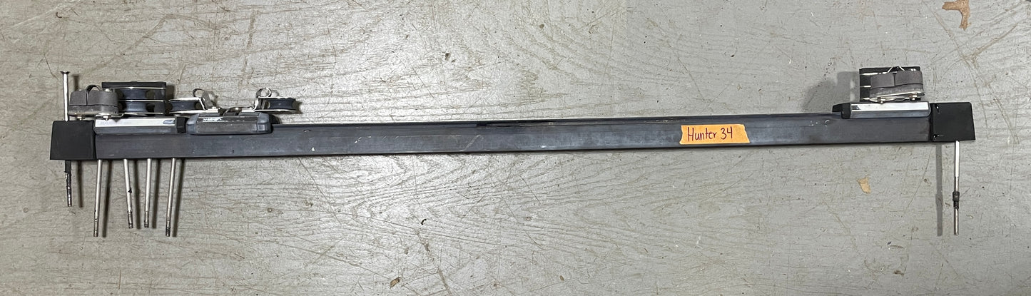 Long metal tool with various attachments on a gray surface