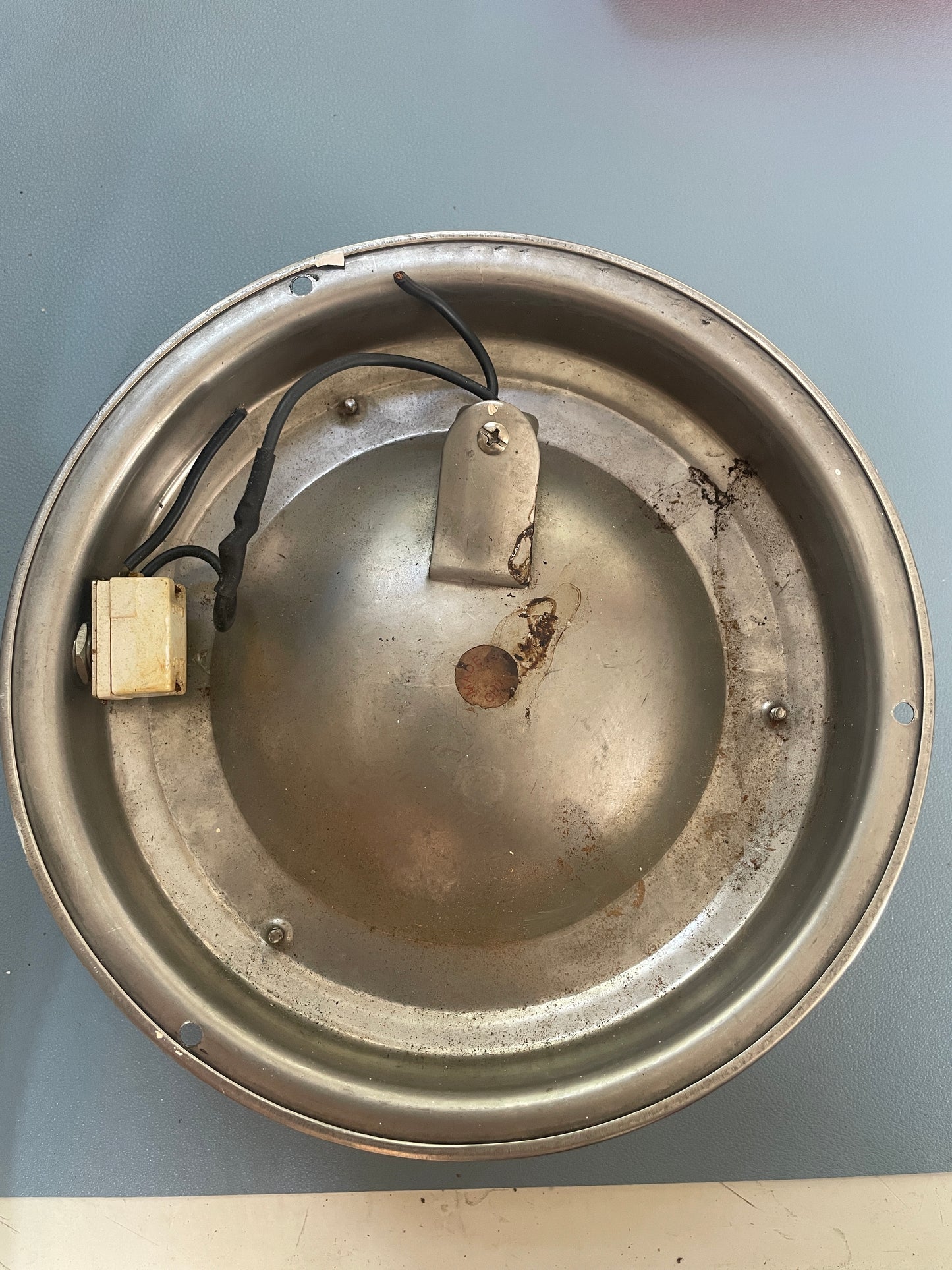 Metallic circular component with wires on a gray background
