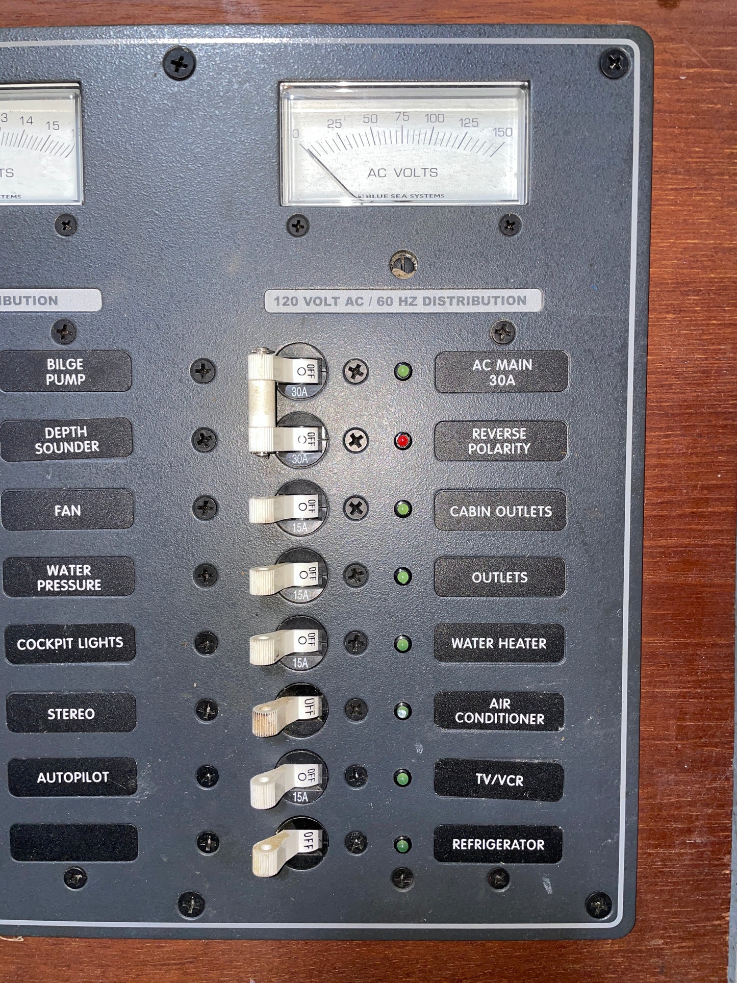 Control panel with various switches and labels on a wooden surface