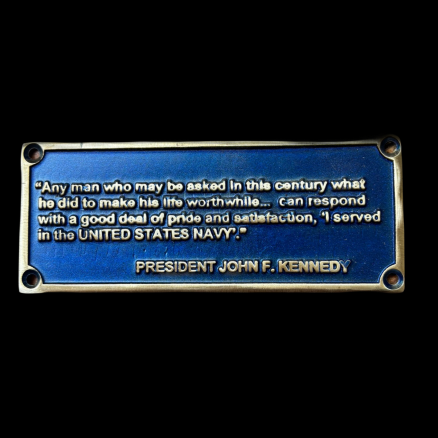 Blue plaque with text attributed to President John F. Kennedy on a black background