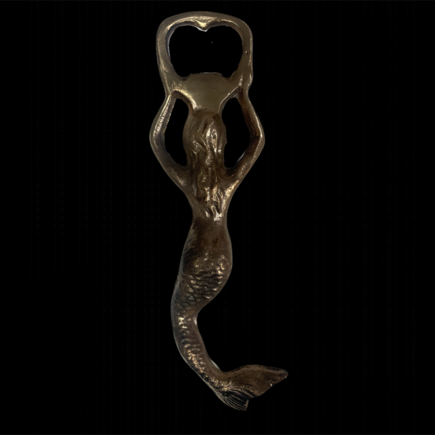 Mermaid-shaped bottle opener on a black background