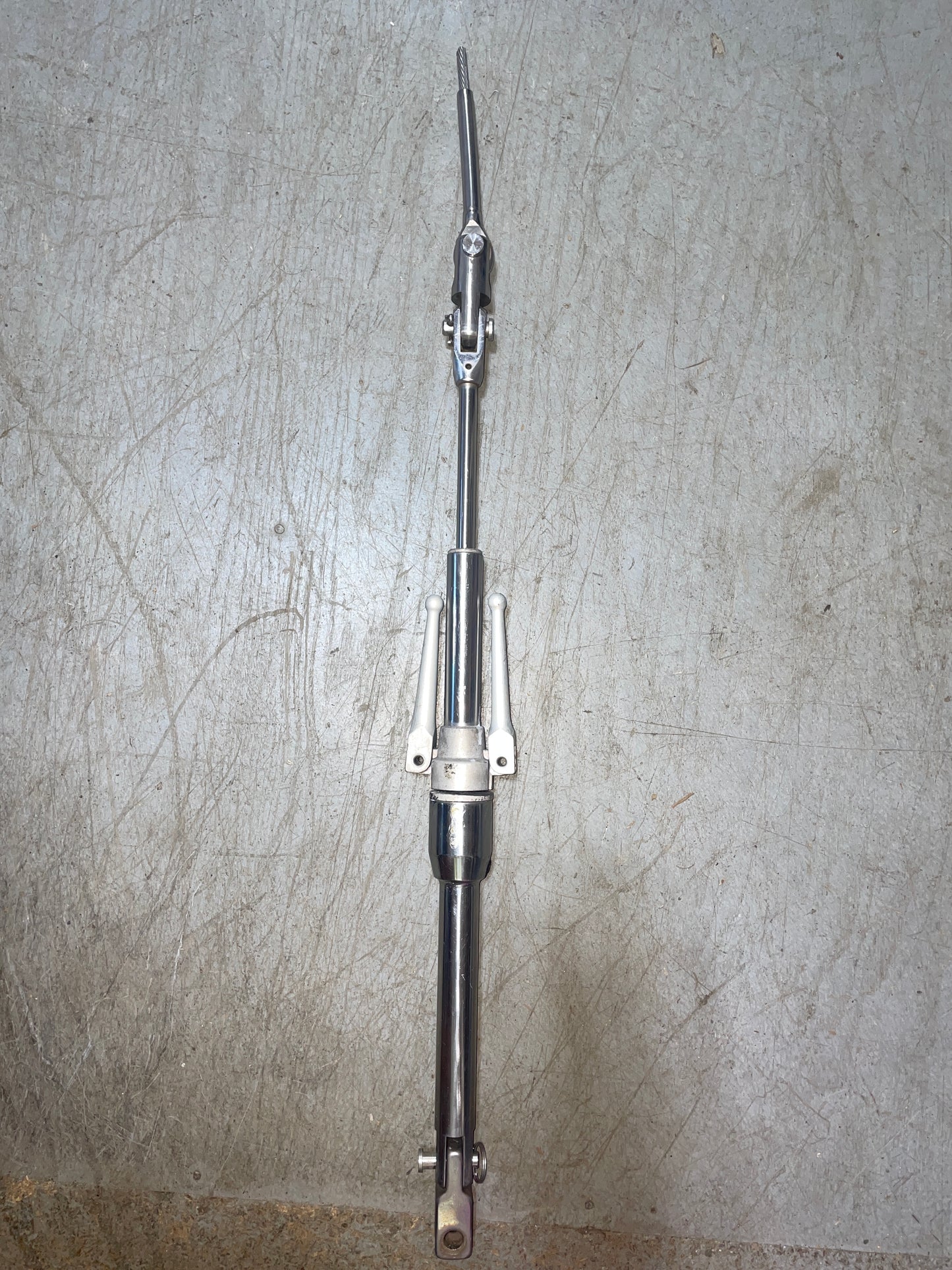 Metal steering rack on a textured gray surface