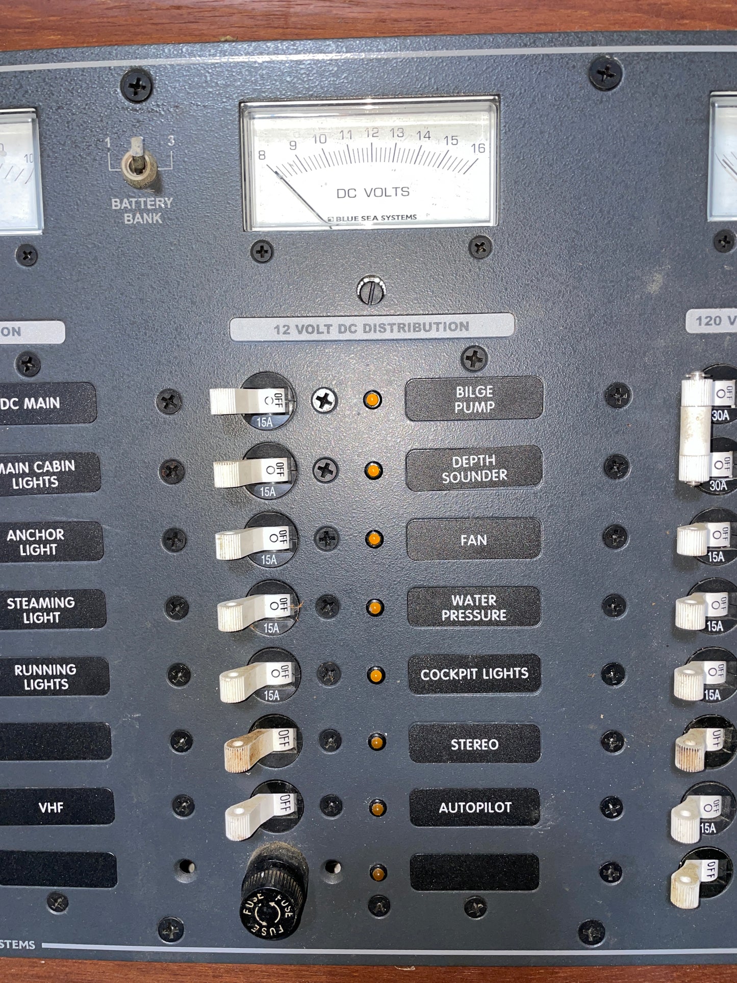 Control panel with switches and a meter on a wooden background