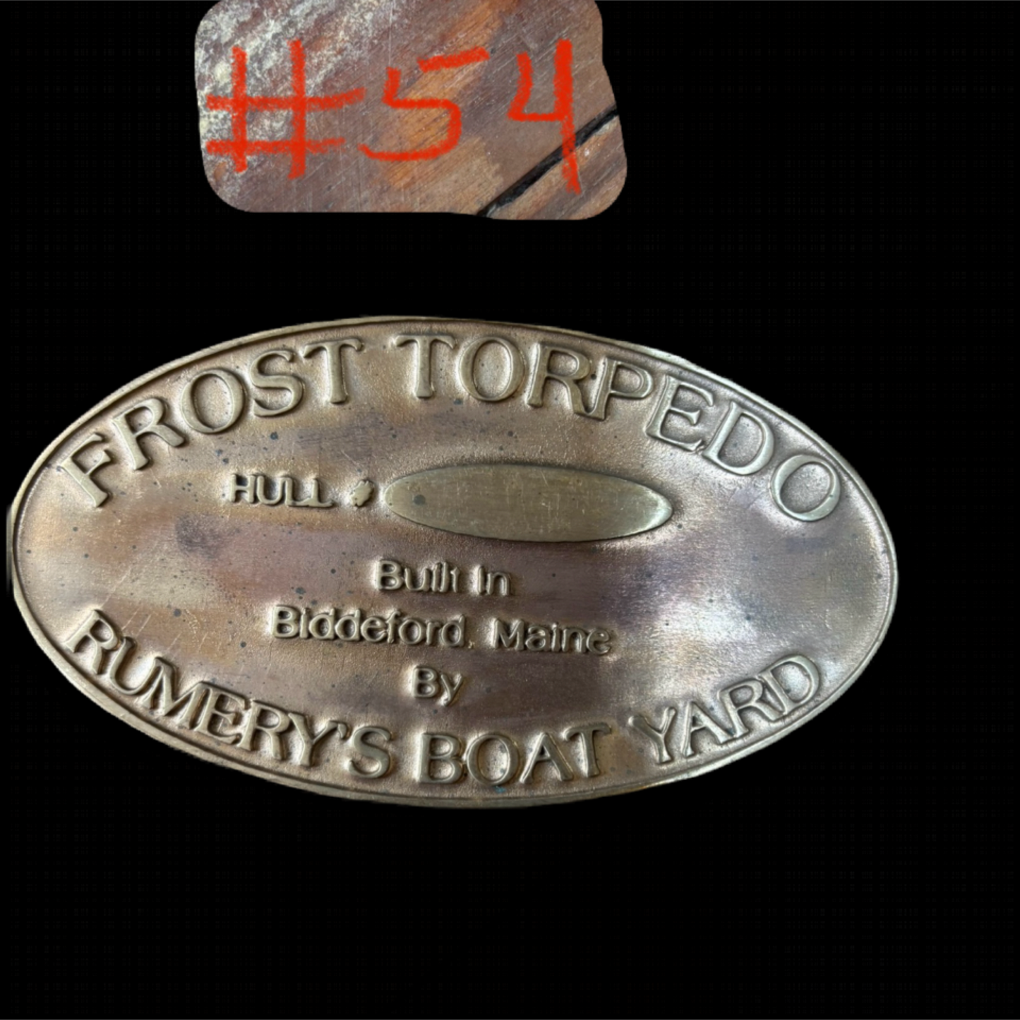 Metal plaque with 'Frost Torpedo' branding on a black background