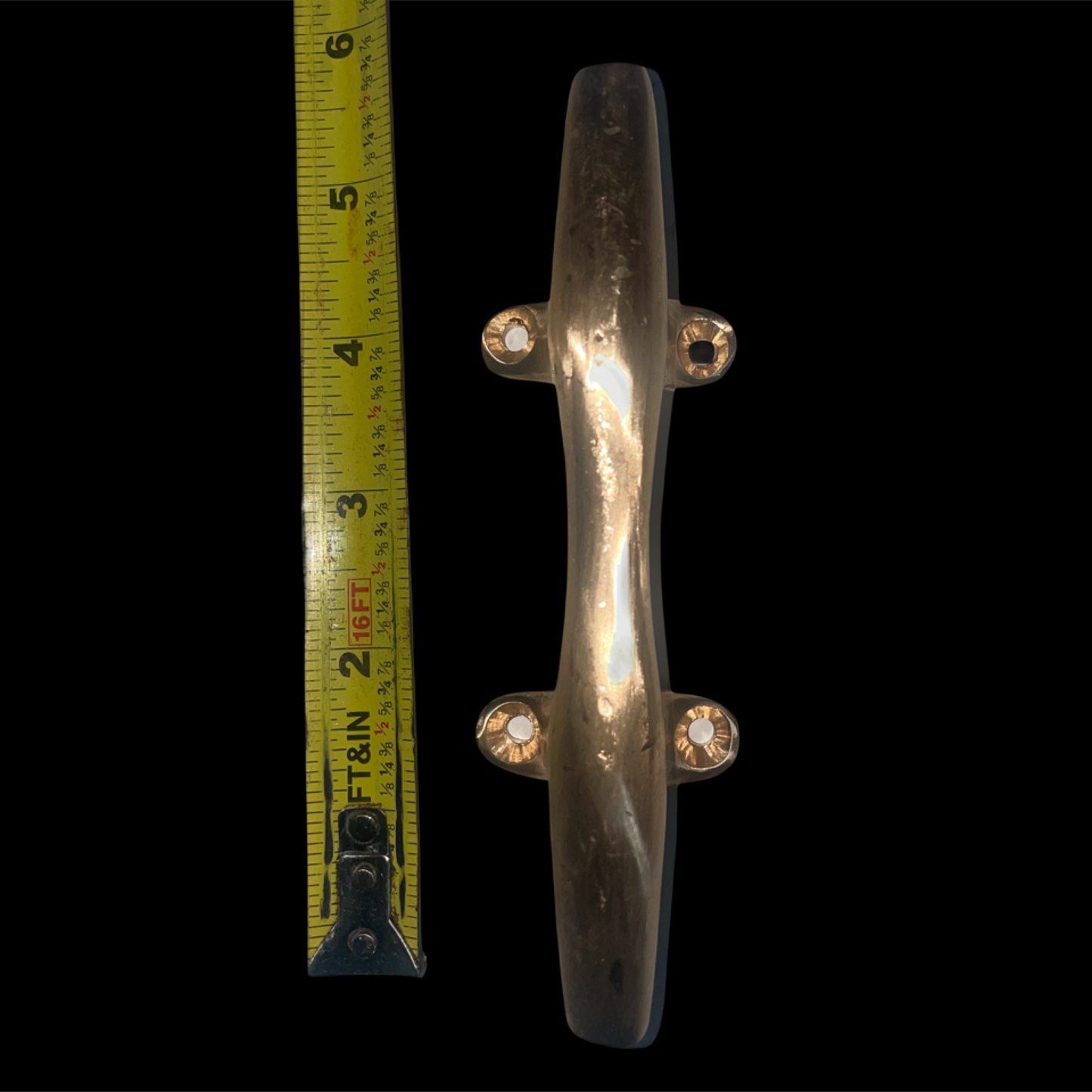 Metallic door handle with a measuring tape on a black background