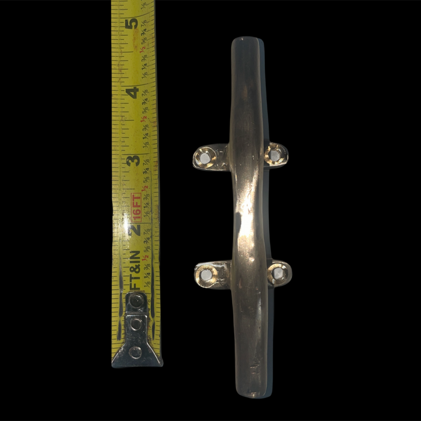 Clear plastic handle with metal brackets next to a tape measure on a black background
