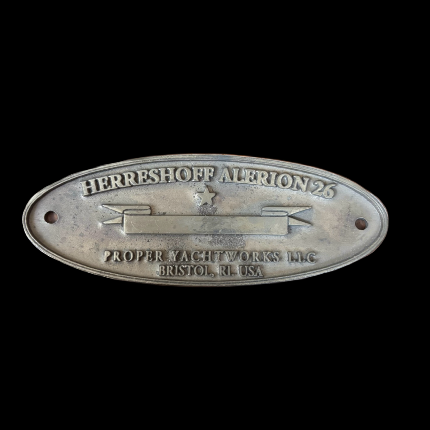 Metal plaque with 'Herreshoff Alerion 26' text on a black background