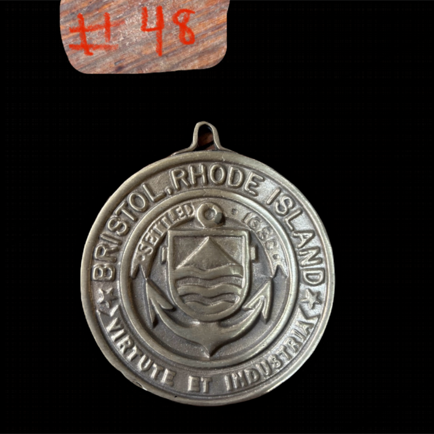 Medal with 'Bristol, Rhode Island' text and emblem on a black background
