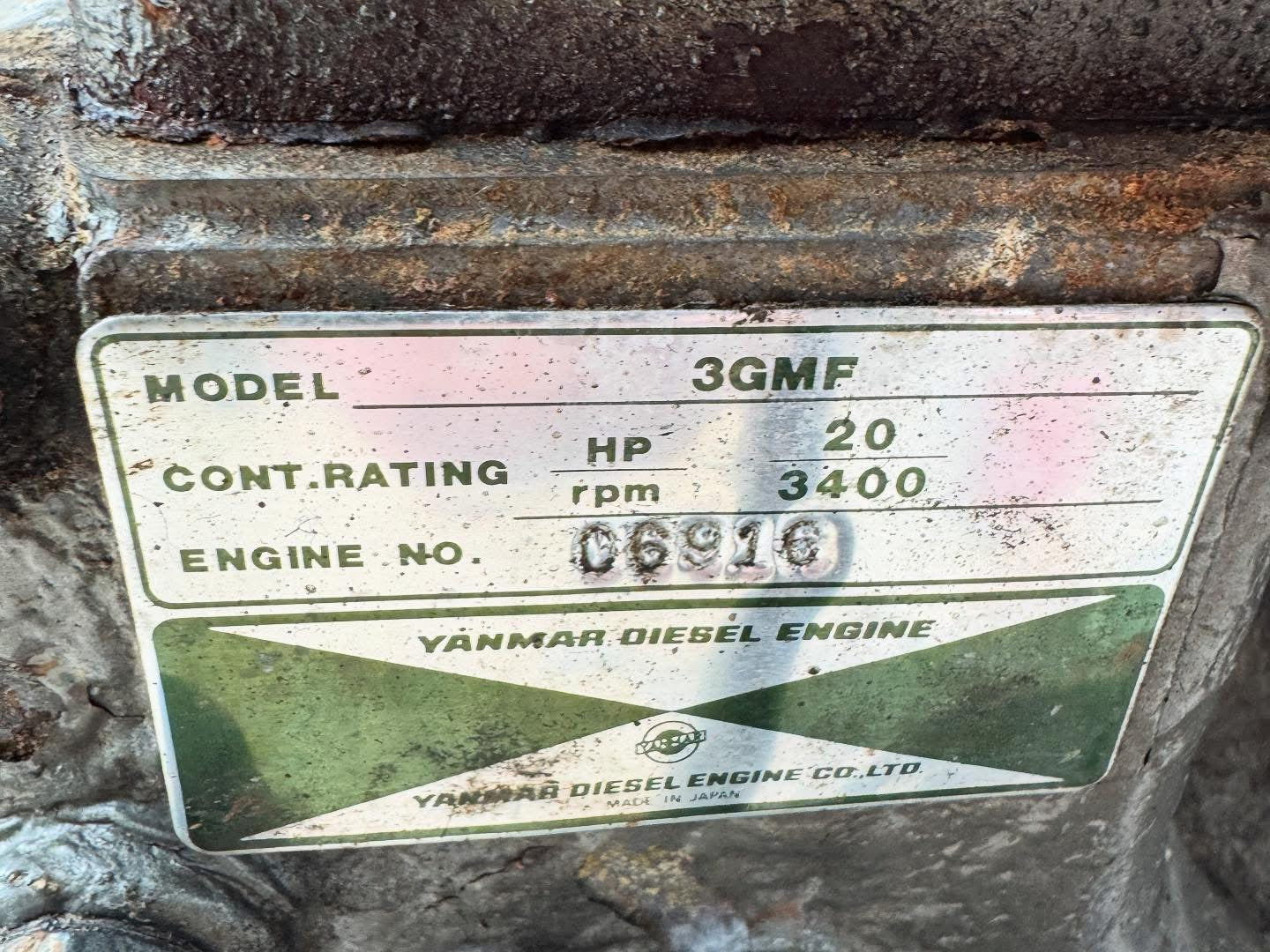 Rust-covered Yanmar Diesel Engine label with model details on a metal surface.