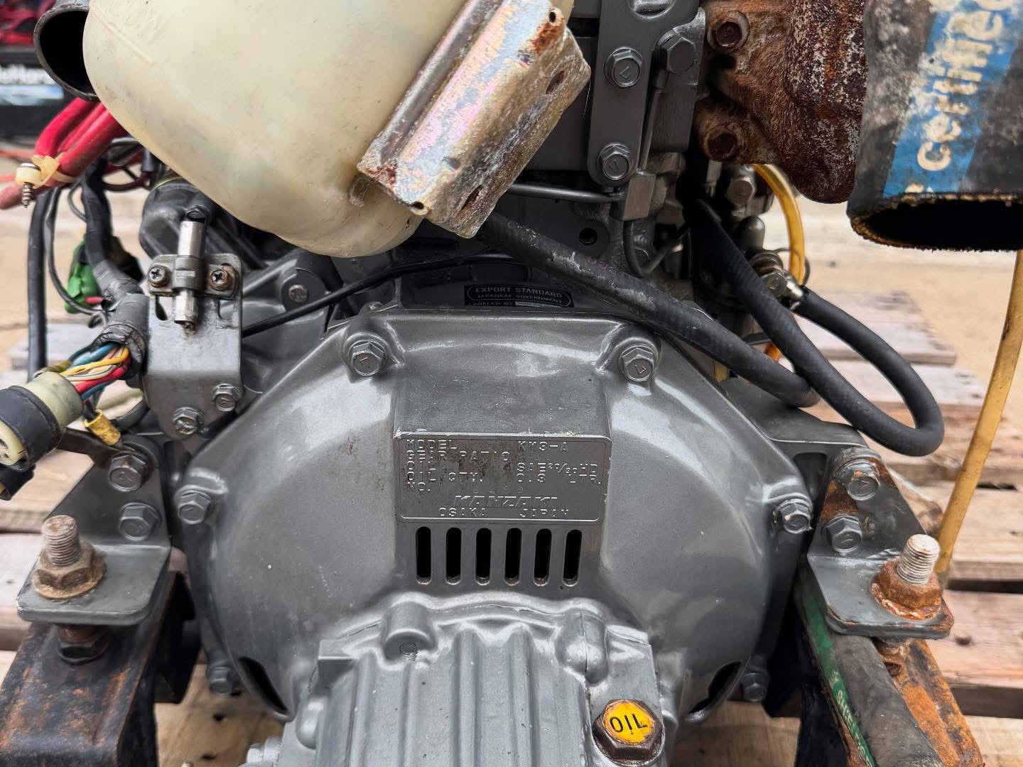 Close-up of a mechanical engine with visible rust and components on a wooden surface.