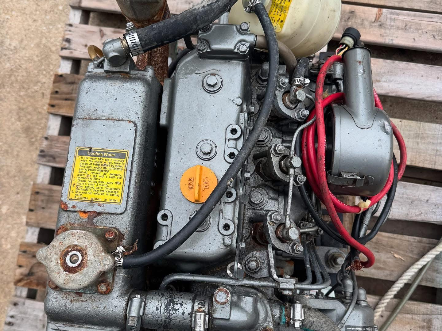 Engine on a wooden pallet with visible wiring and components.