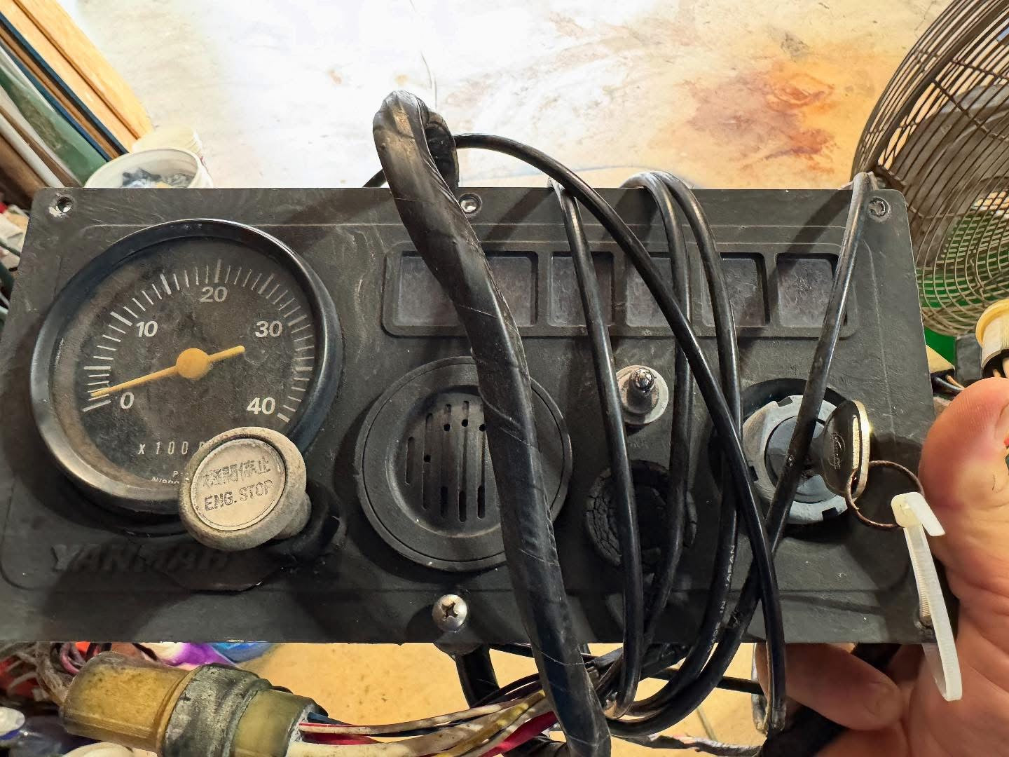 Vintage dashboard with gauges and wiring held by a person
