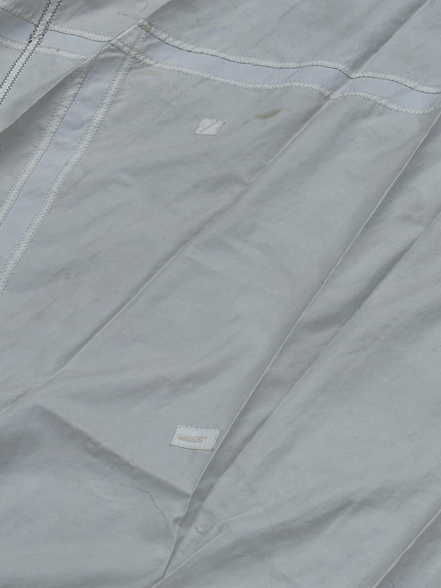 Close-up of a gray fabric with stitching details and a brand label.