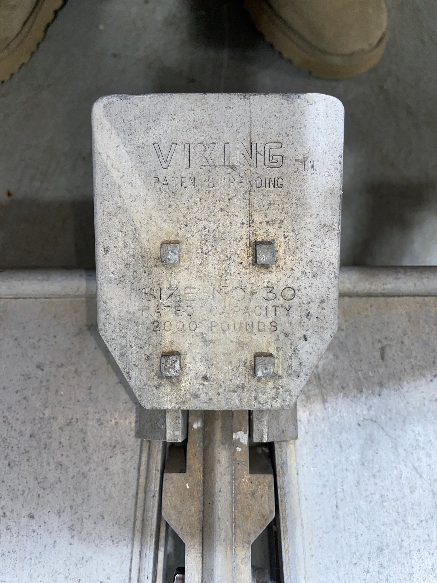 Metal component with 'Viking' branding on a concrete surface