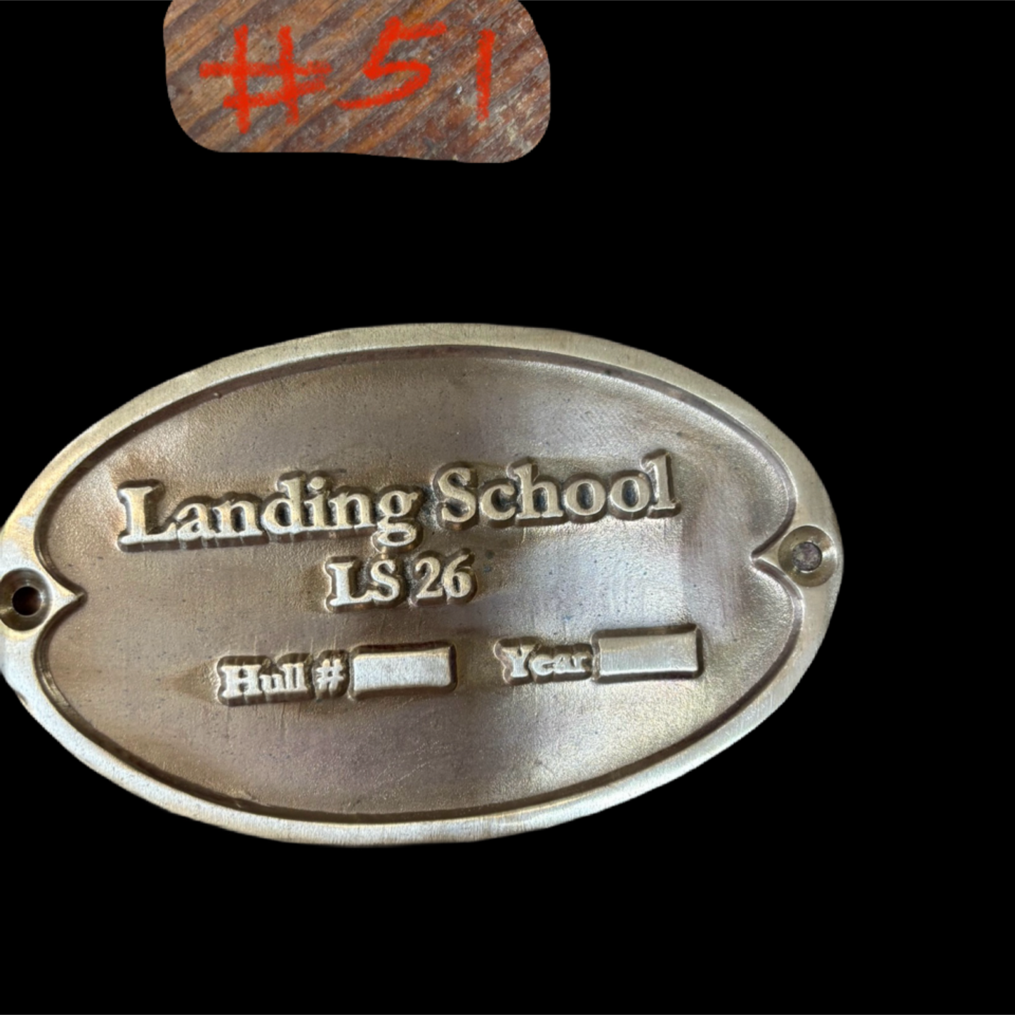 Metal plaque with 'Landing School LS 26' text on a black background