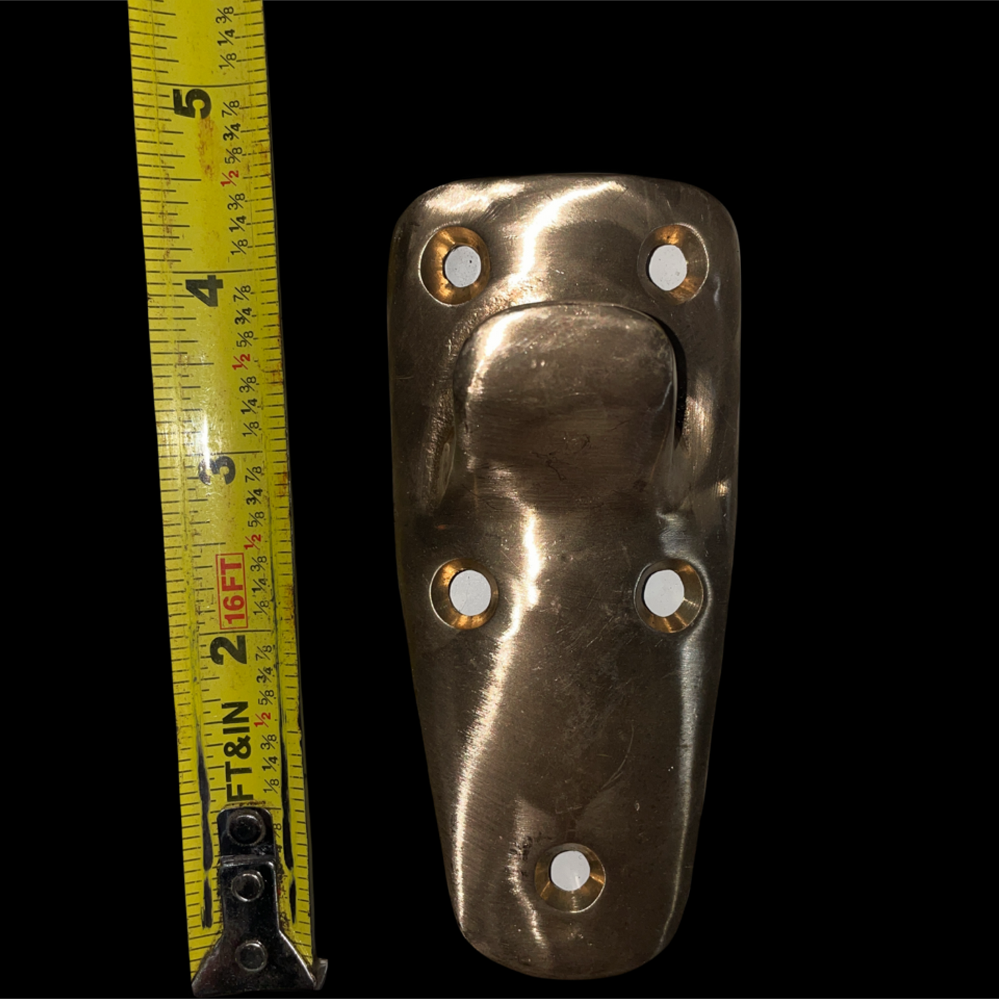 Metallic door handle with measurement tape on a black background