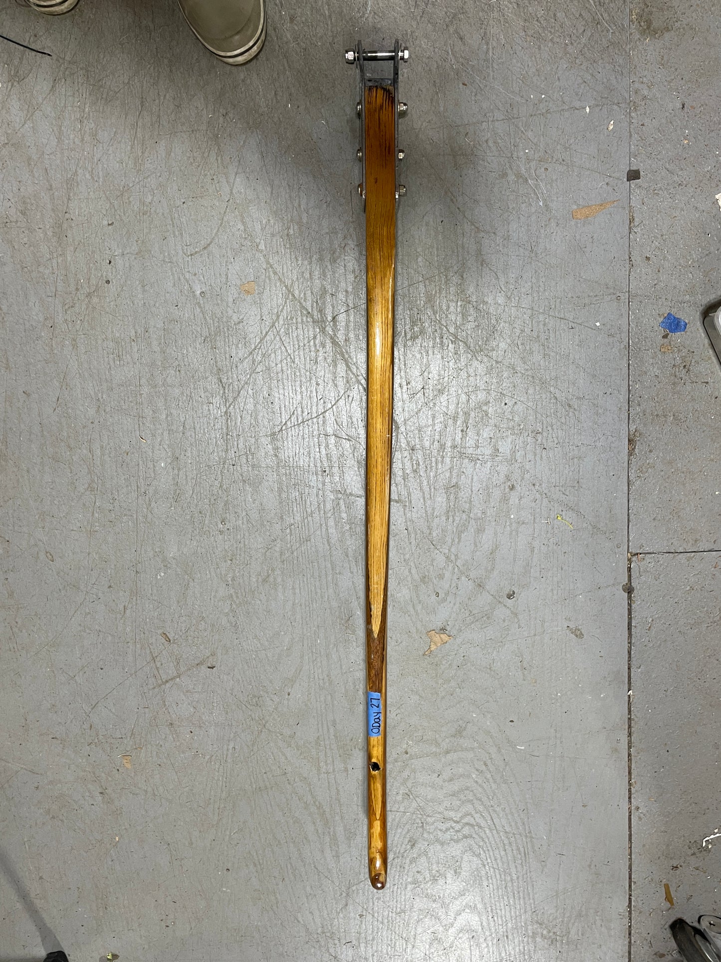Wooden rod with metal components on a metallic surface