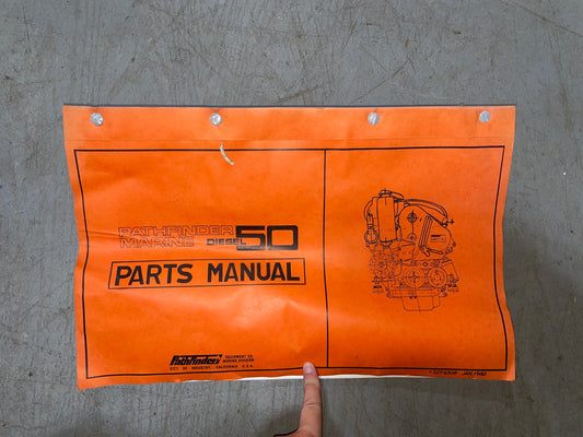 Orange parts manual for Caterpillar diesel engines on a gray surface