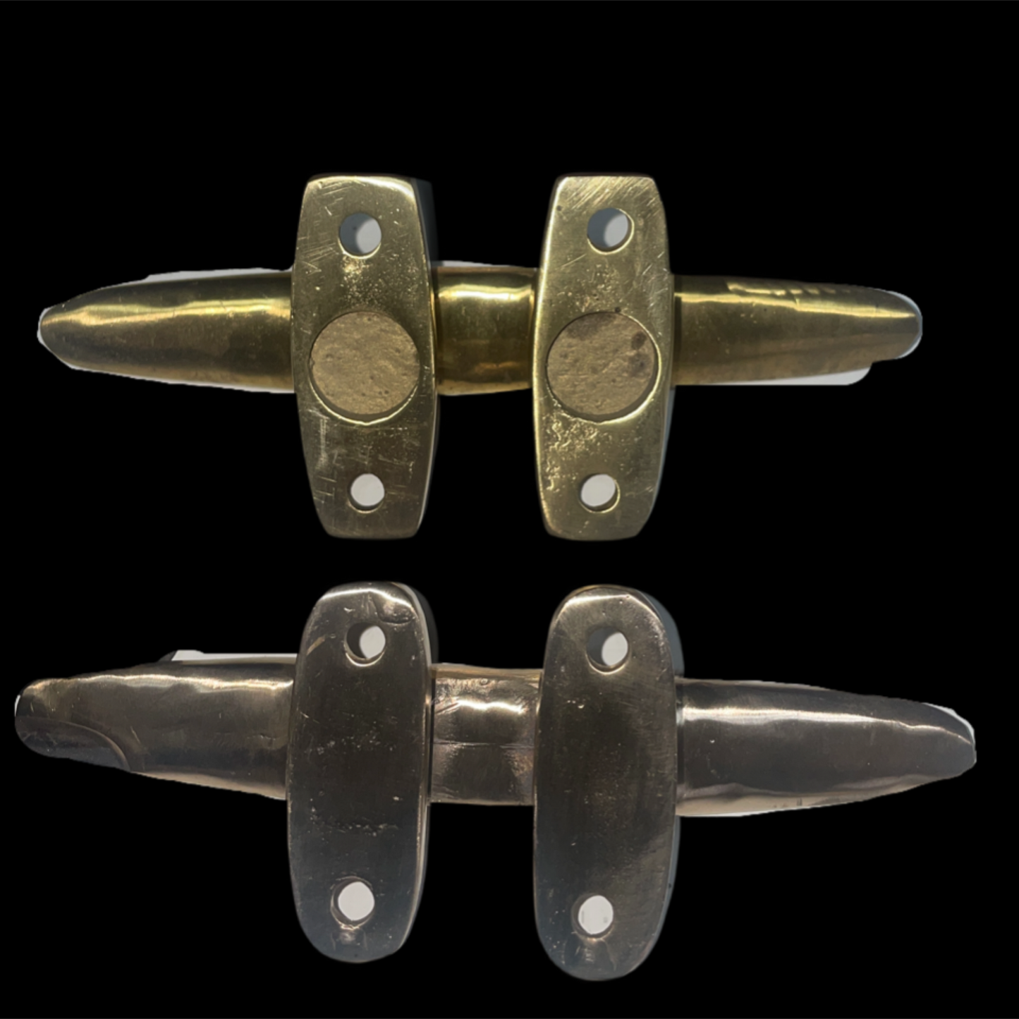 Two pairs of brass door handles on a black background