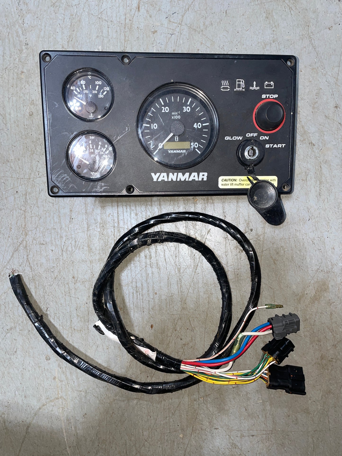 Yanmar gauge panel with wiring harness on a concrete surface