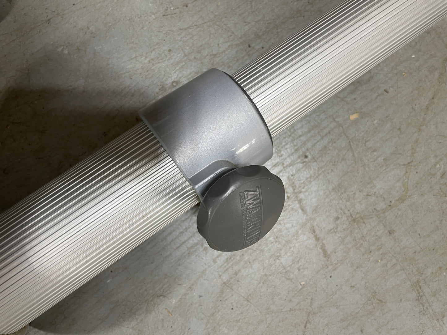Metal rod with a gray cap on a concrete surface