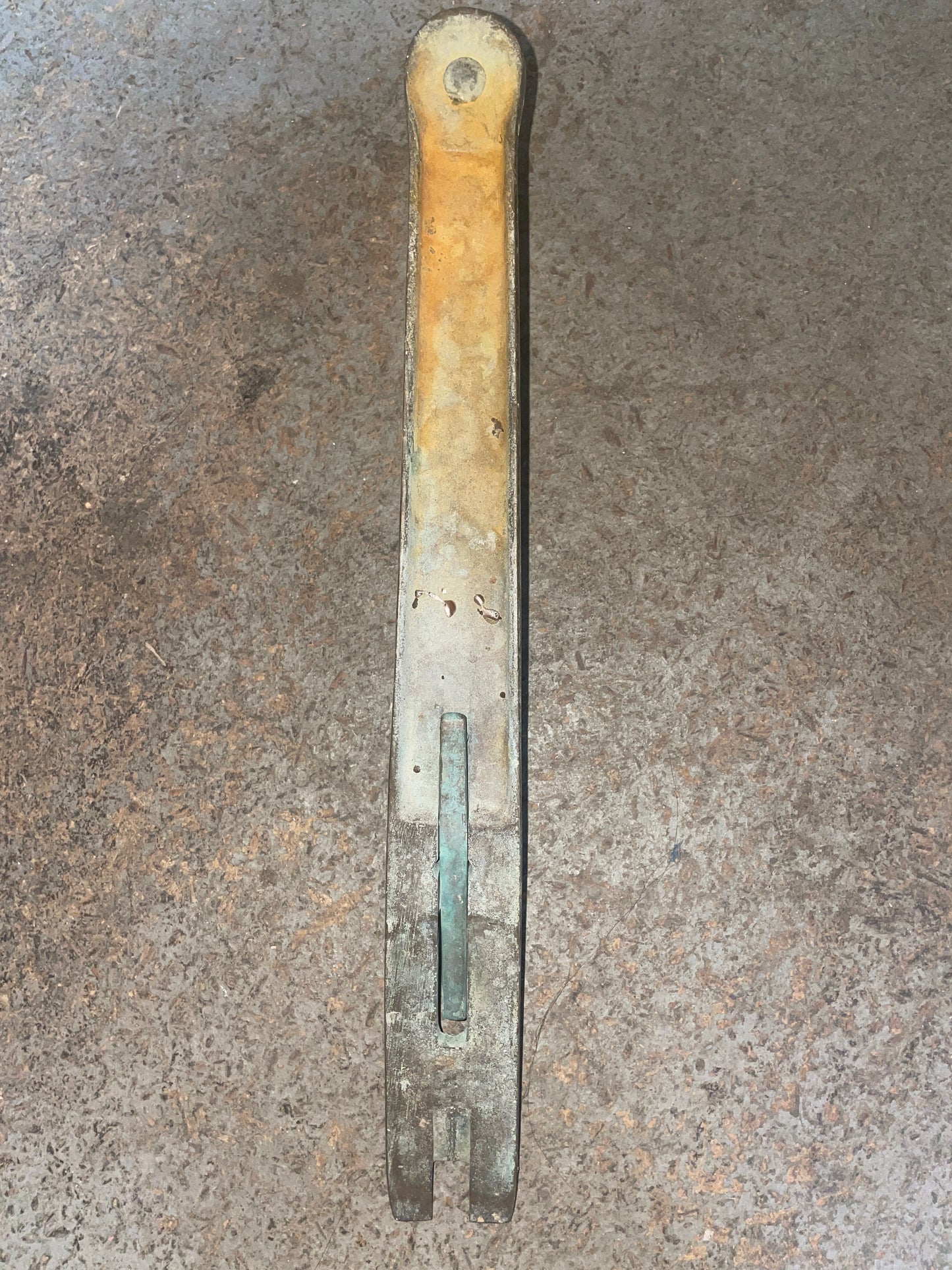 Metal tool with a worn handle on a textured surface