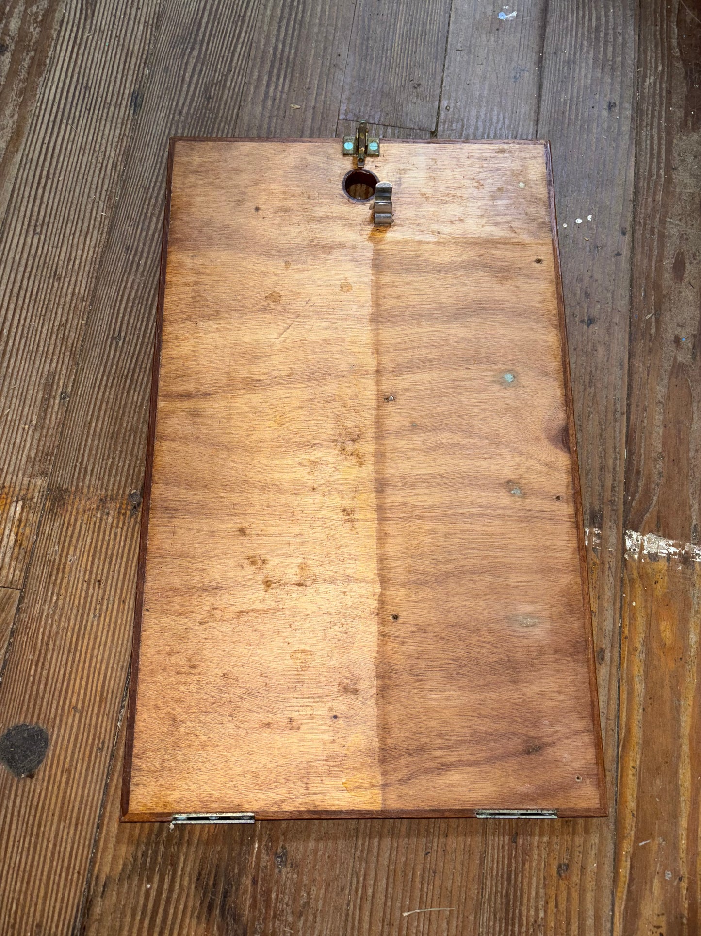 Wooden door with hinges on a wooden floor