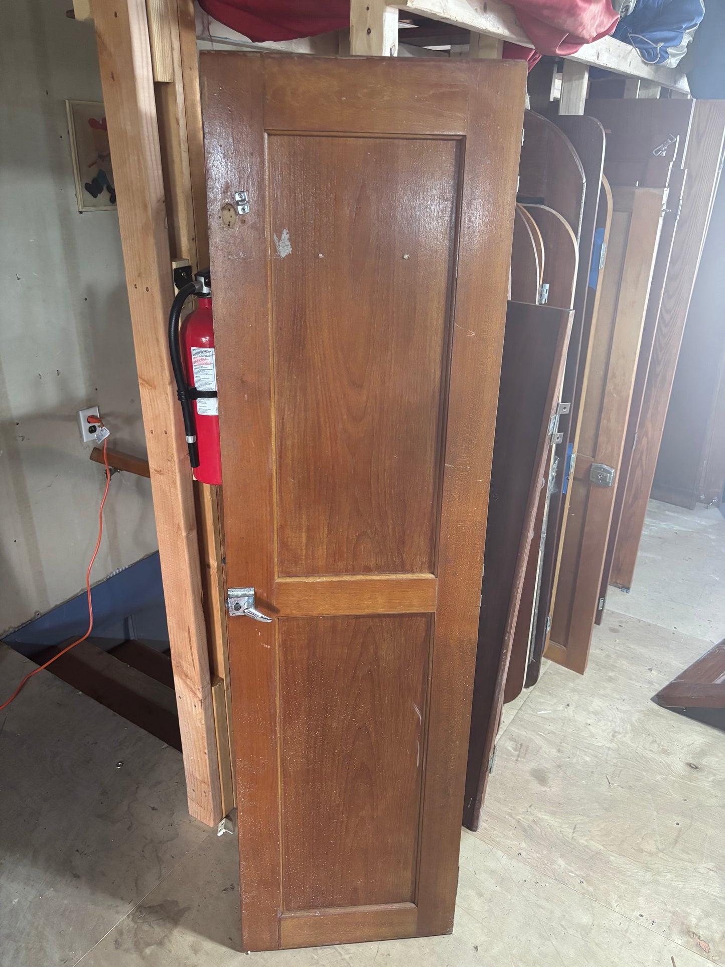Wooden door with fire extinguisher in a storage or warehouse setting