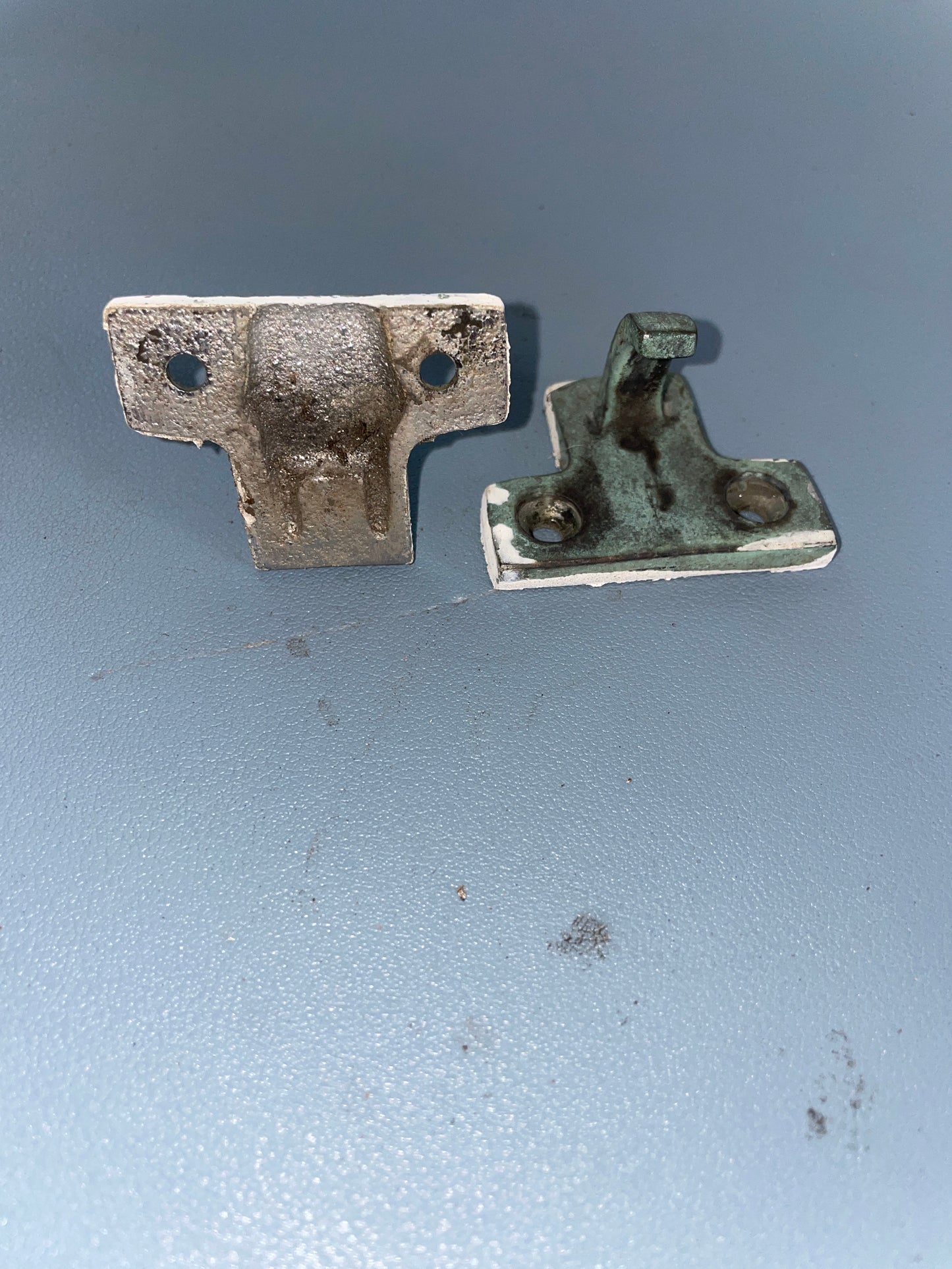 Two metal hinges on a gray background
