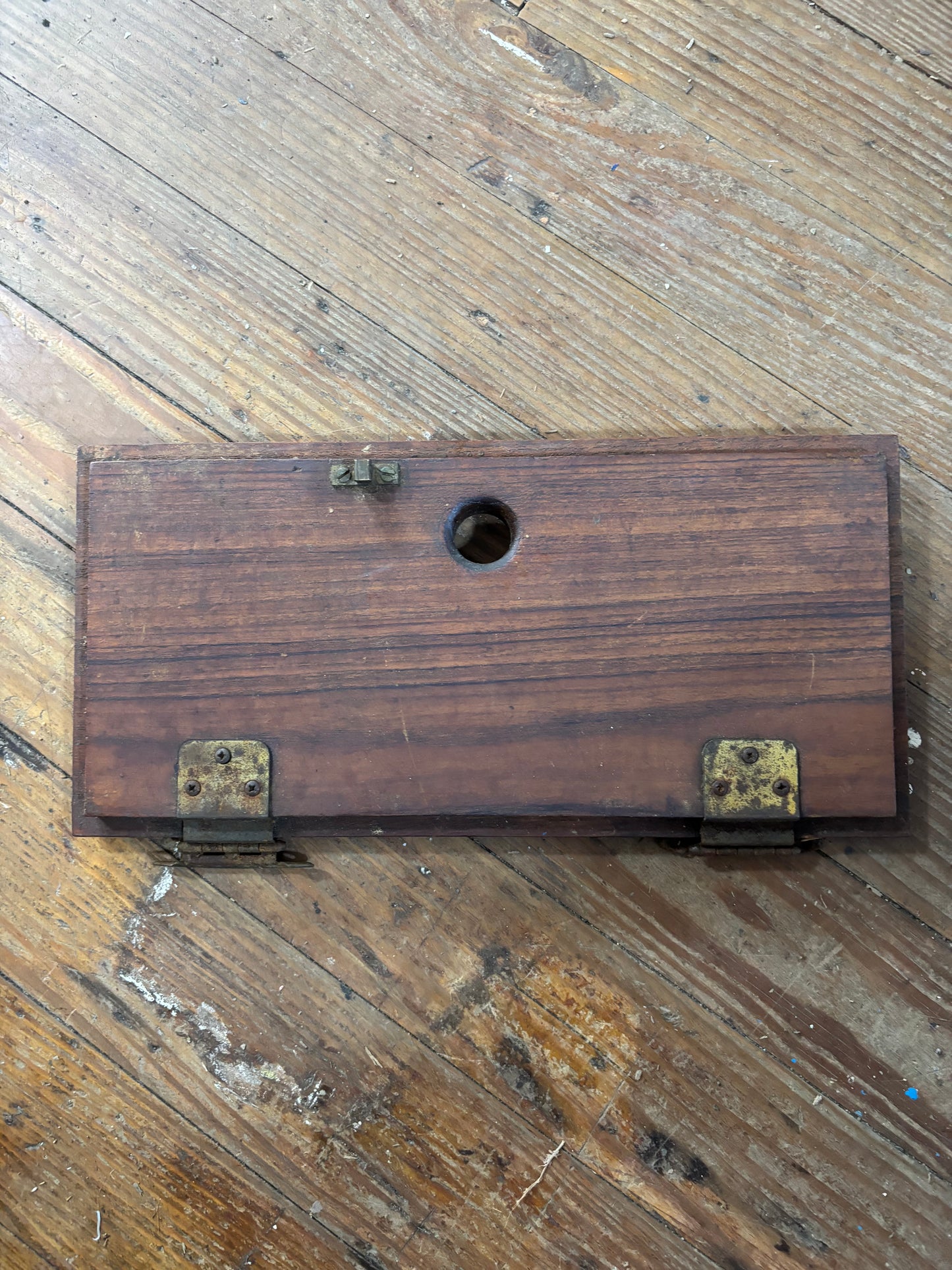 Wooden box with brass hardware on a wooden floor