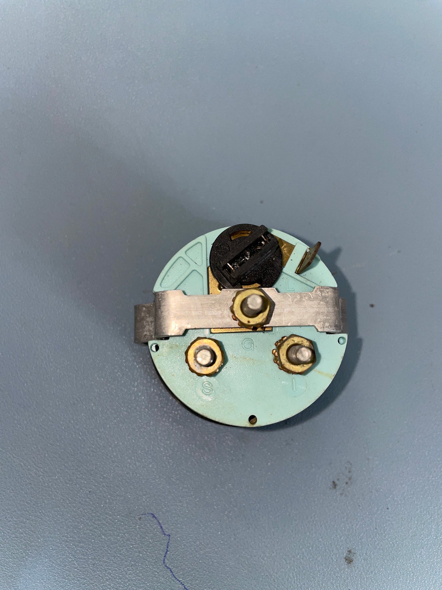 Mechanical component with gears and a central black part on a gray background