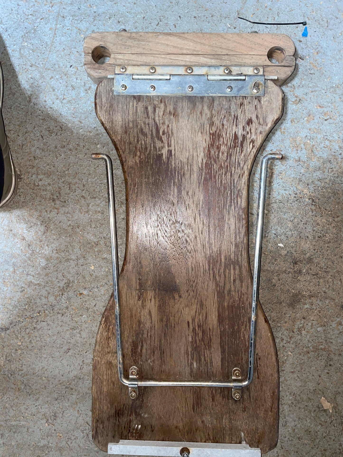 Wooden paddle with metal frame on a concrete surface