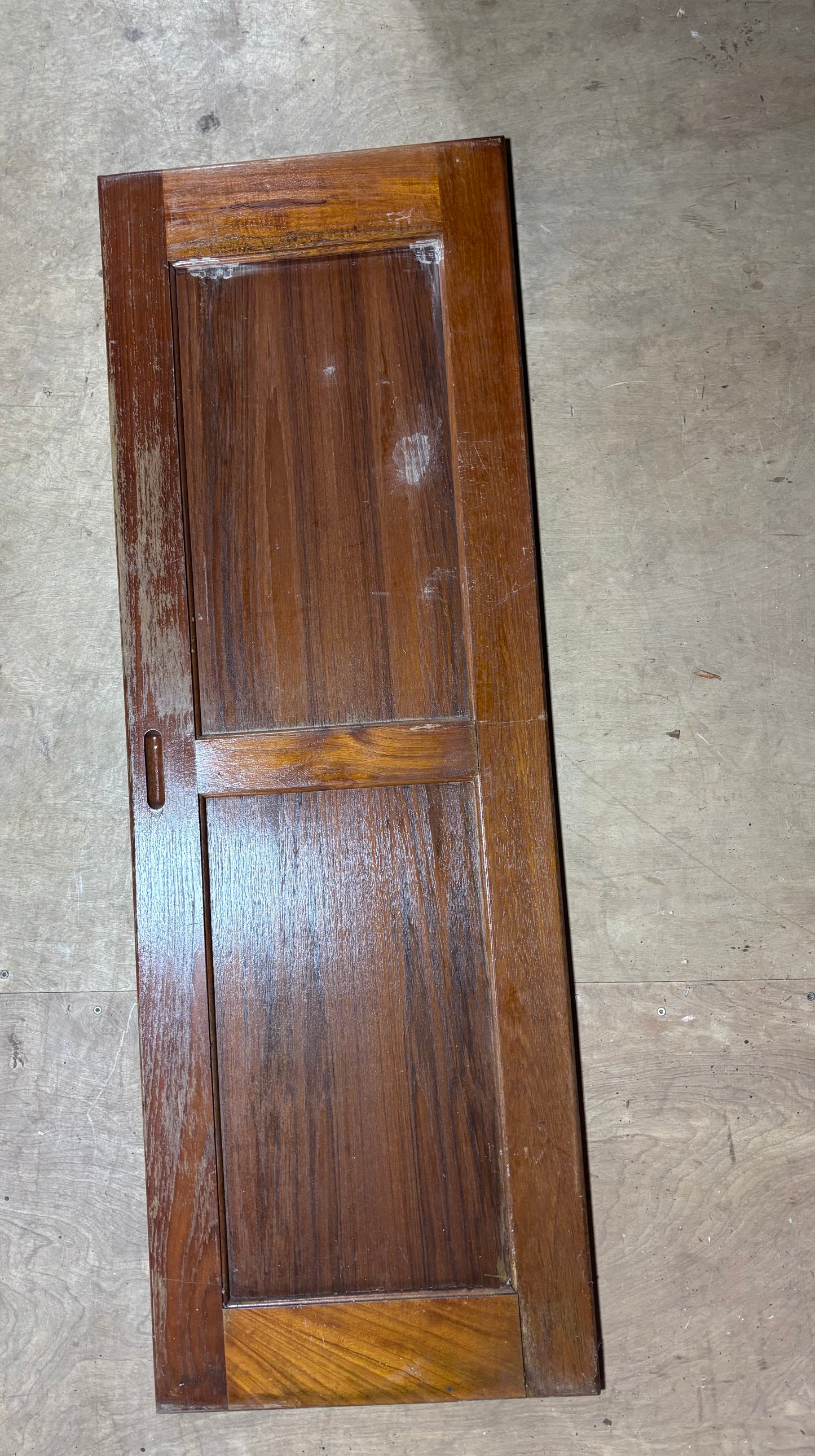 Wooden panel with a checkered pattern on a concrete floor