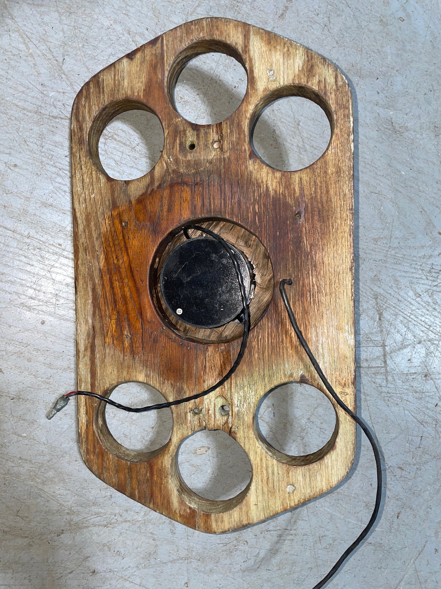 Wooden dial with a black central component on a gray surface