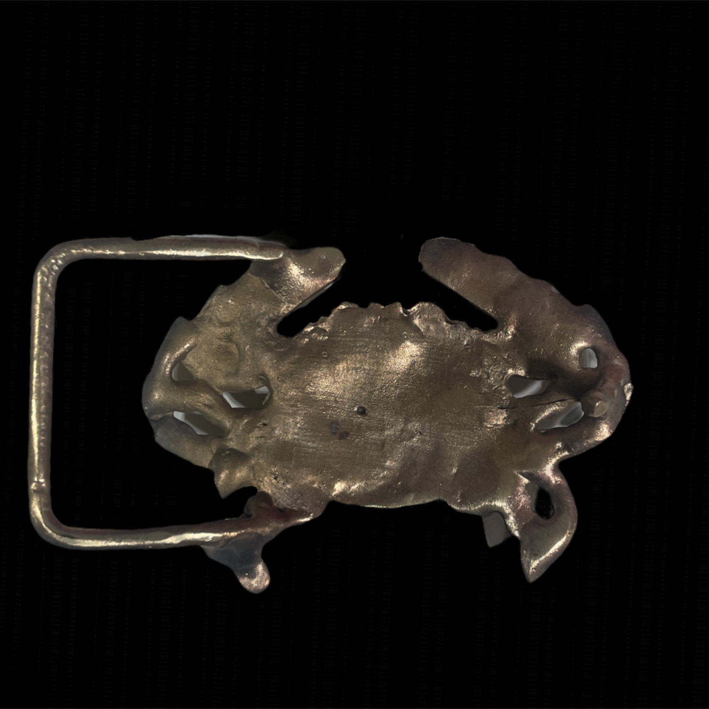 Metallic crab-shaped belt buckle on a black background