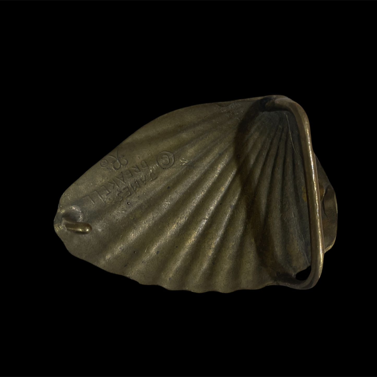 Bronze shell-shaped object on a black background