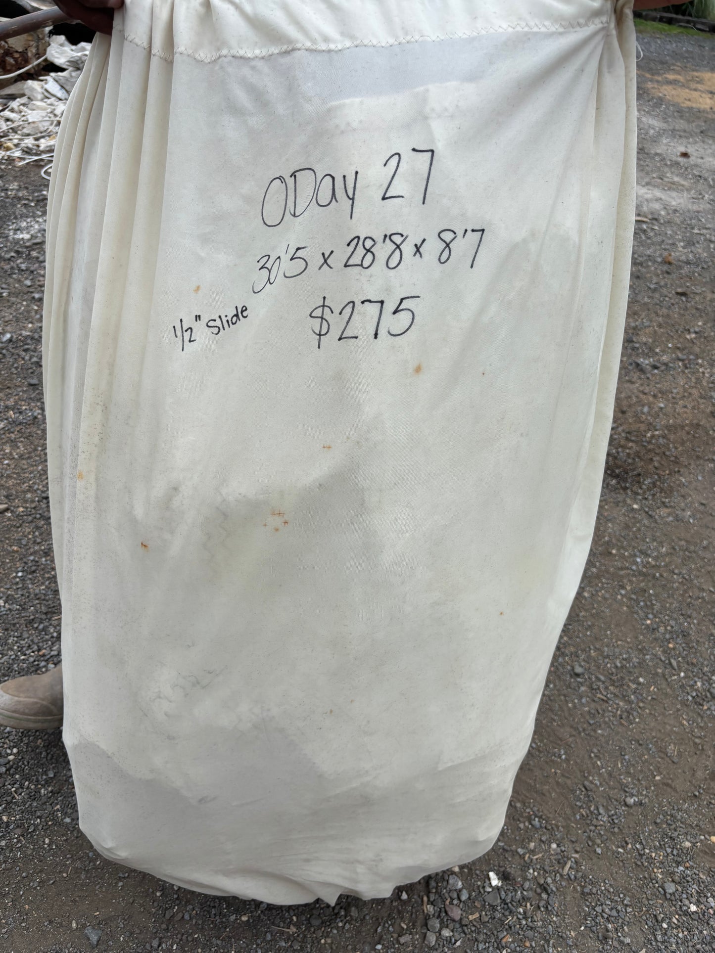 White fabric with measurements and text on a concrete surface