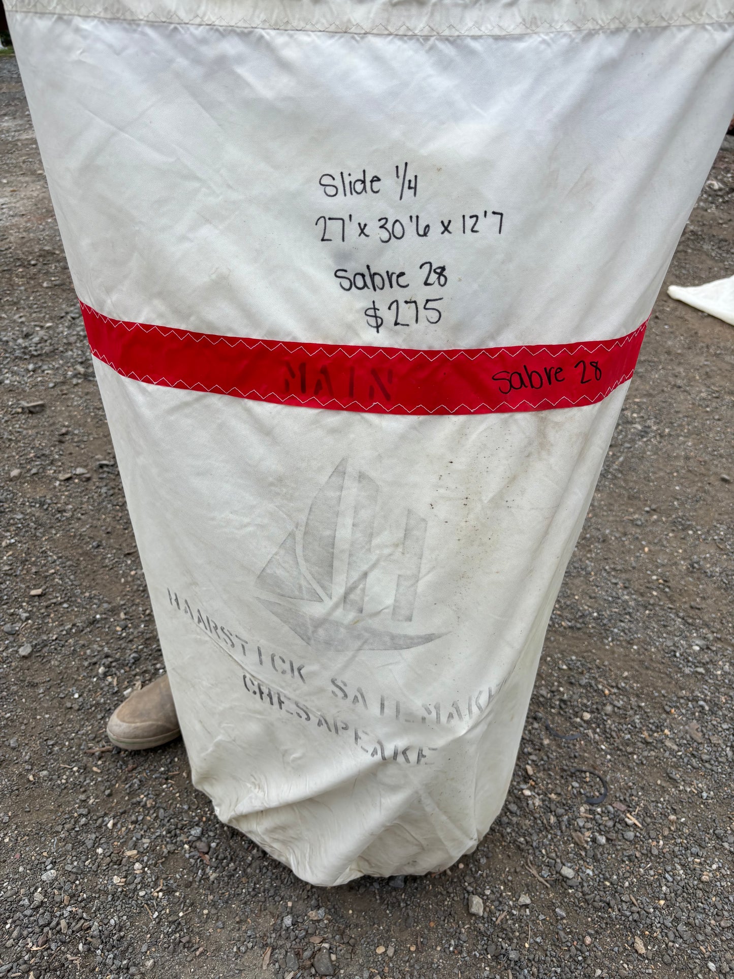 White bag with red strap on a concrete surface