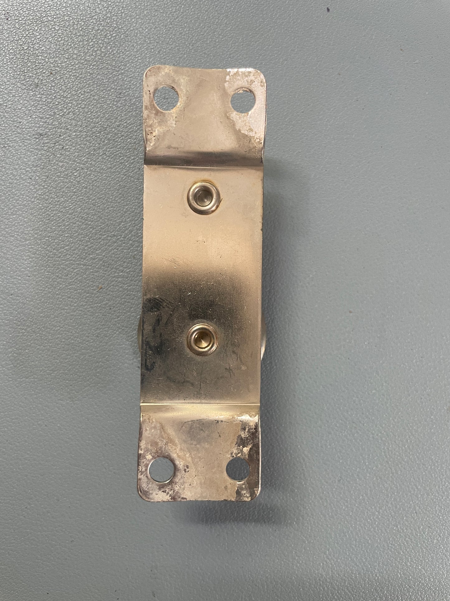Brass metal bracket on a gray background