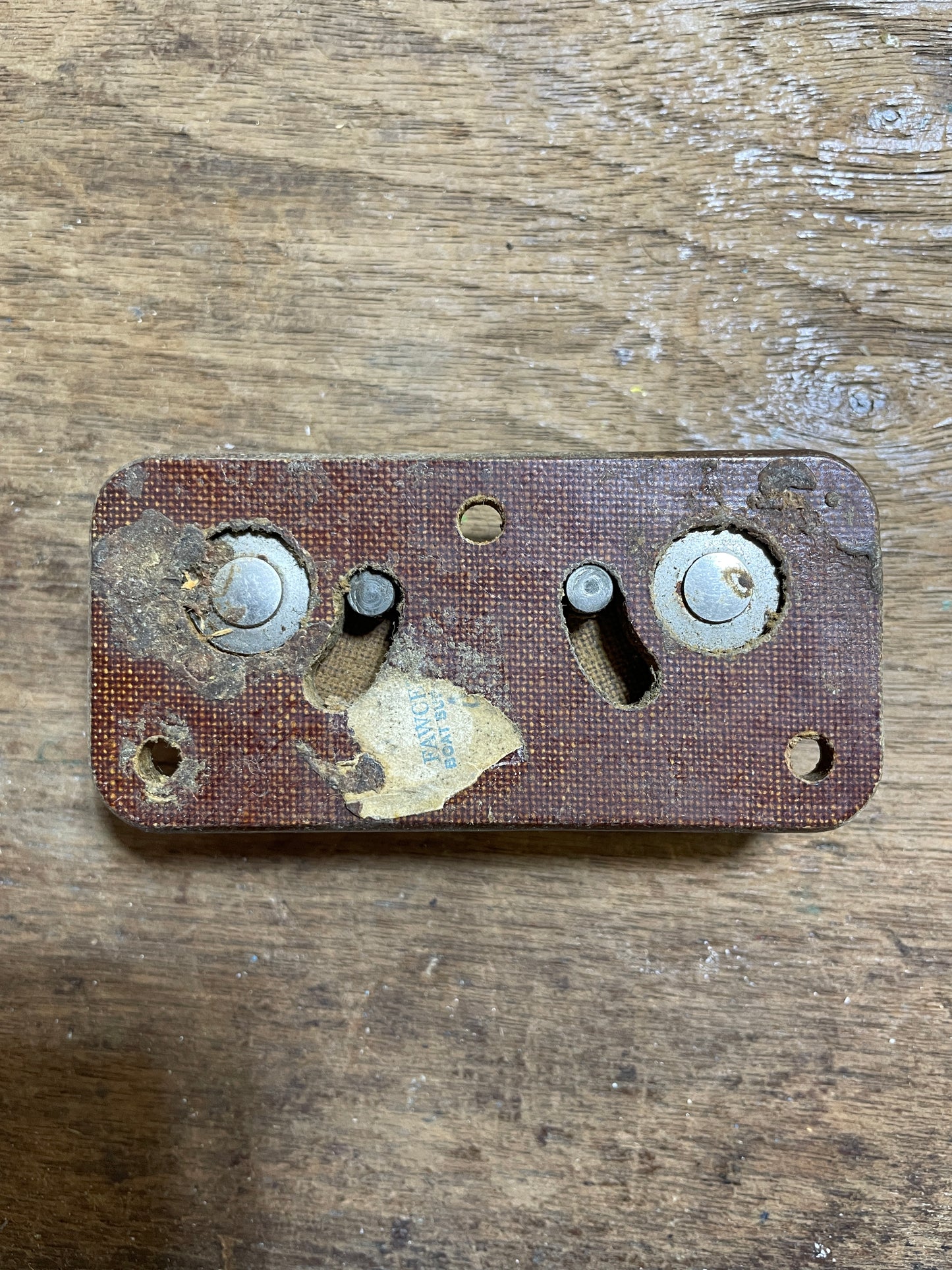 Rust-covered metal switch plate on a wooden surface