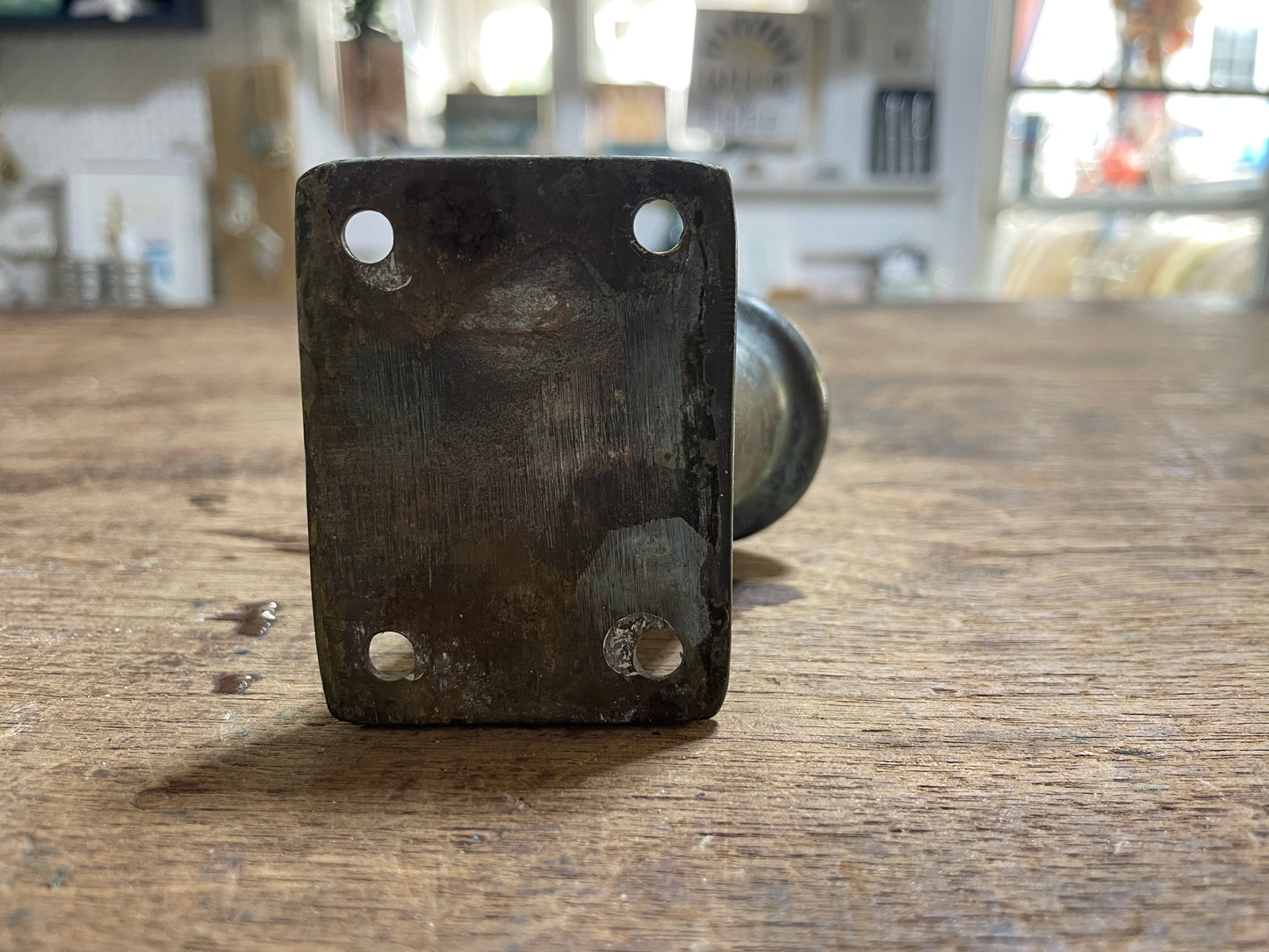 Metal bracket with holes on a wooden surface