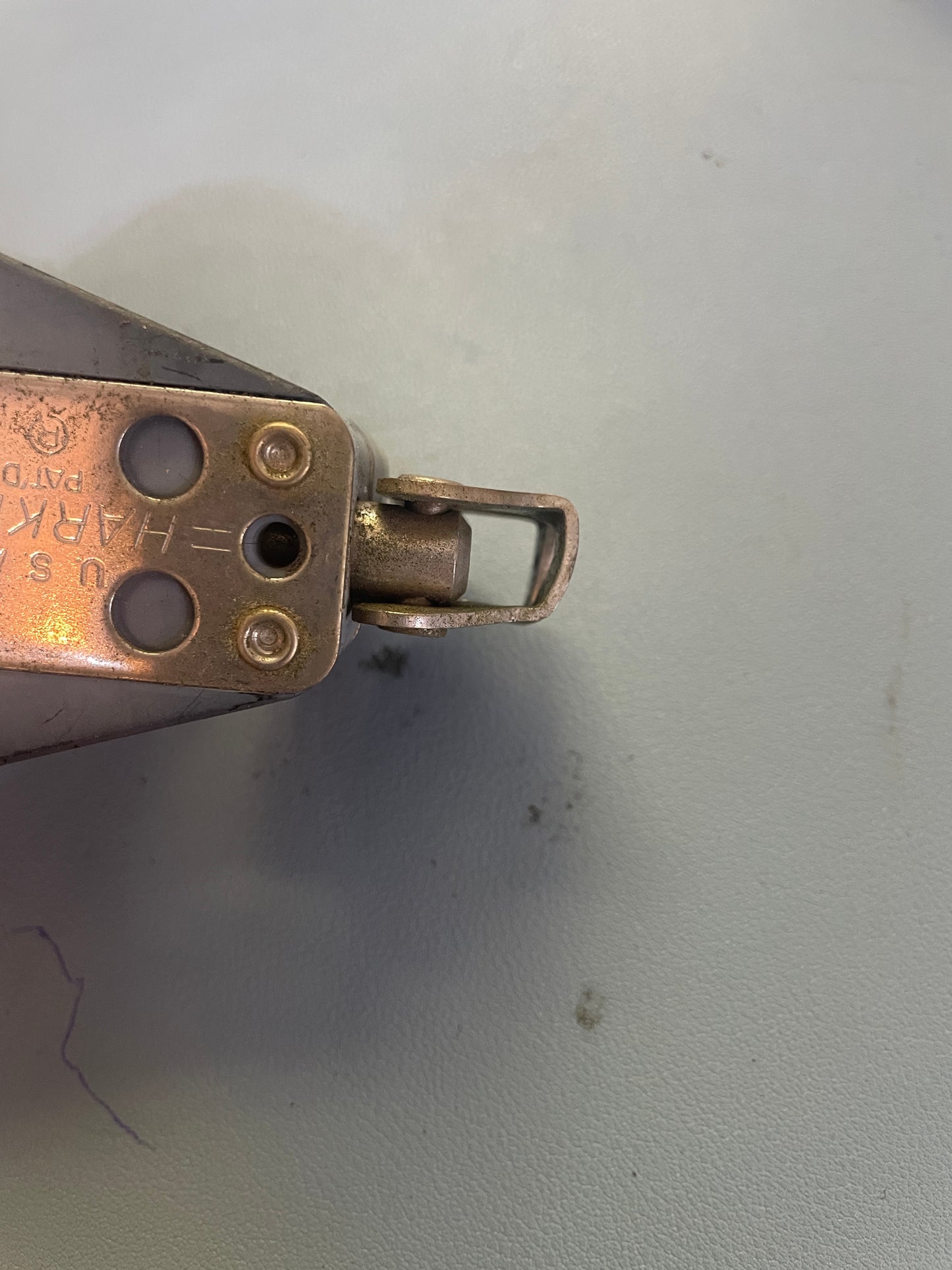 Metal tool with a spring-loaded mechanism on a gray background