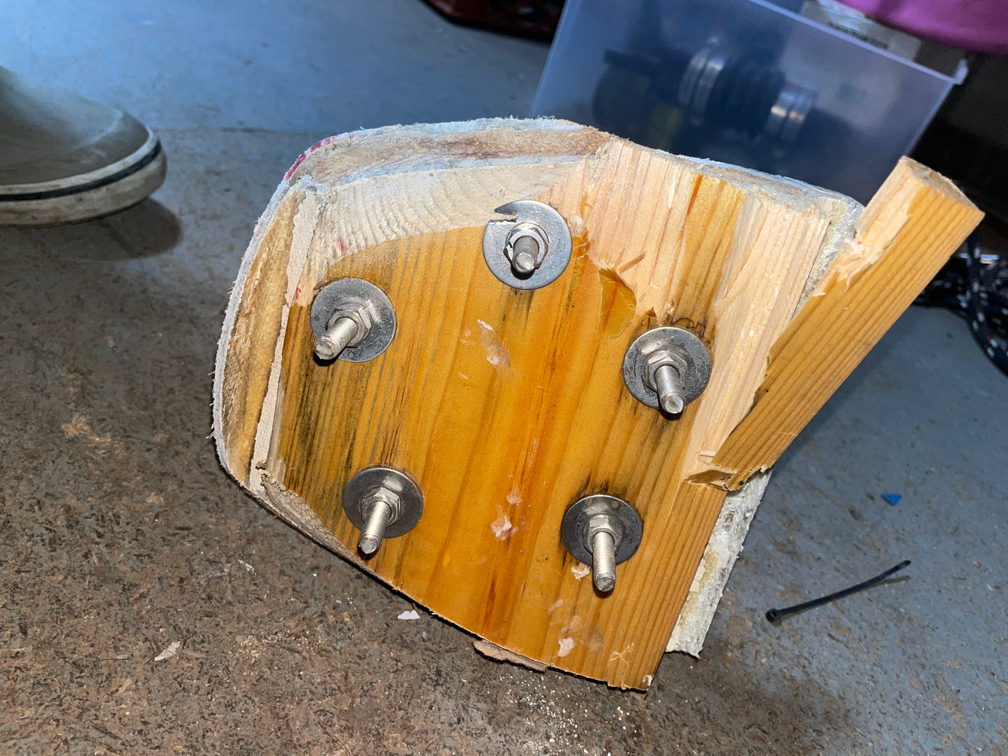 Wooden block with metal bolts on a concrete floor
