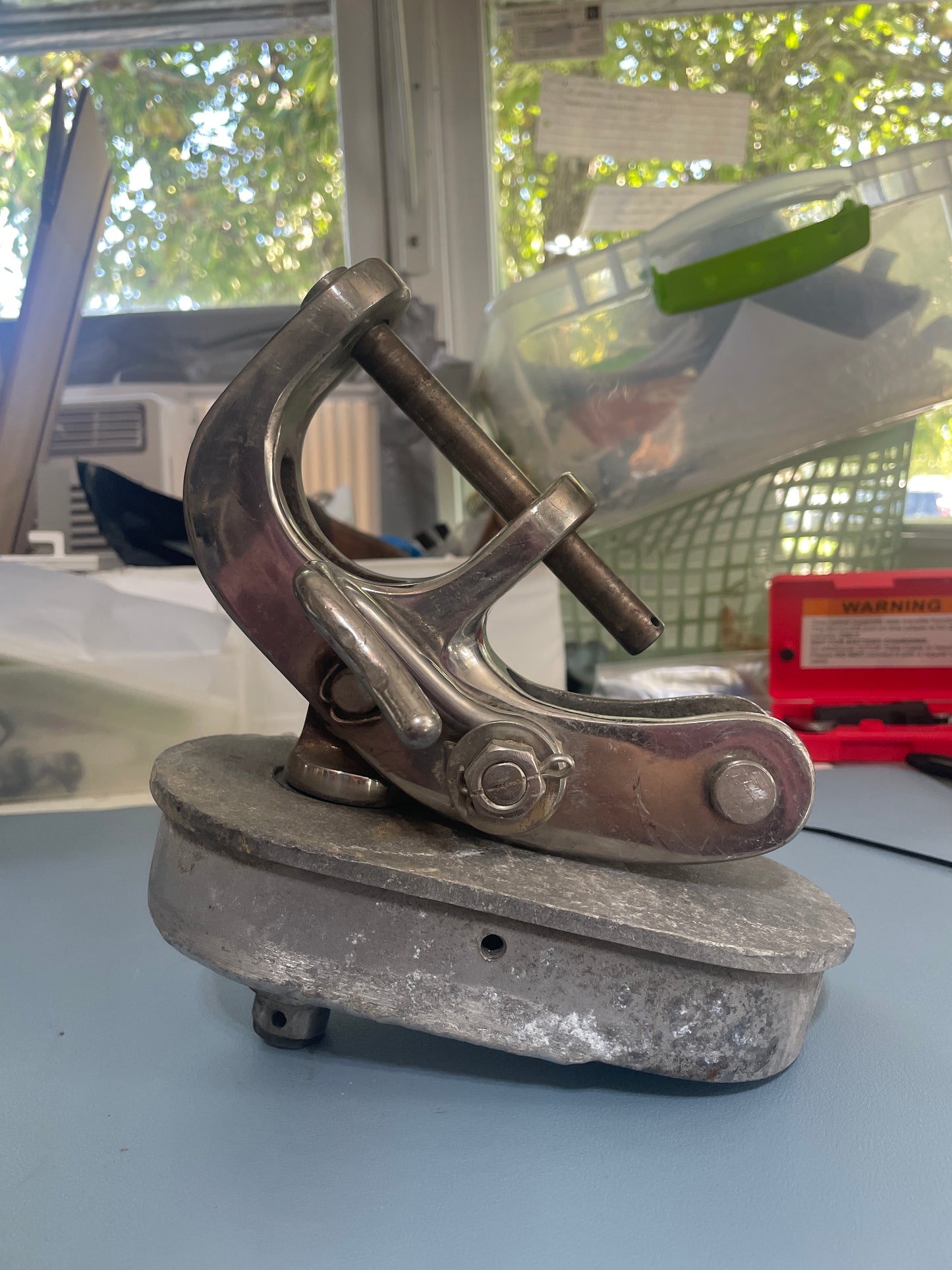 Metal clamp attached to a wall with a blurred background