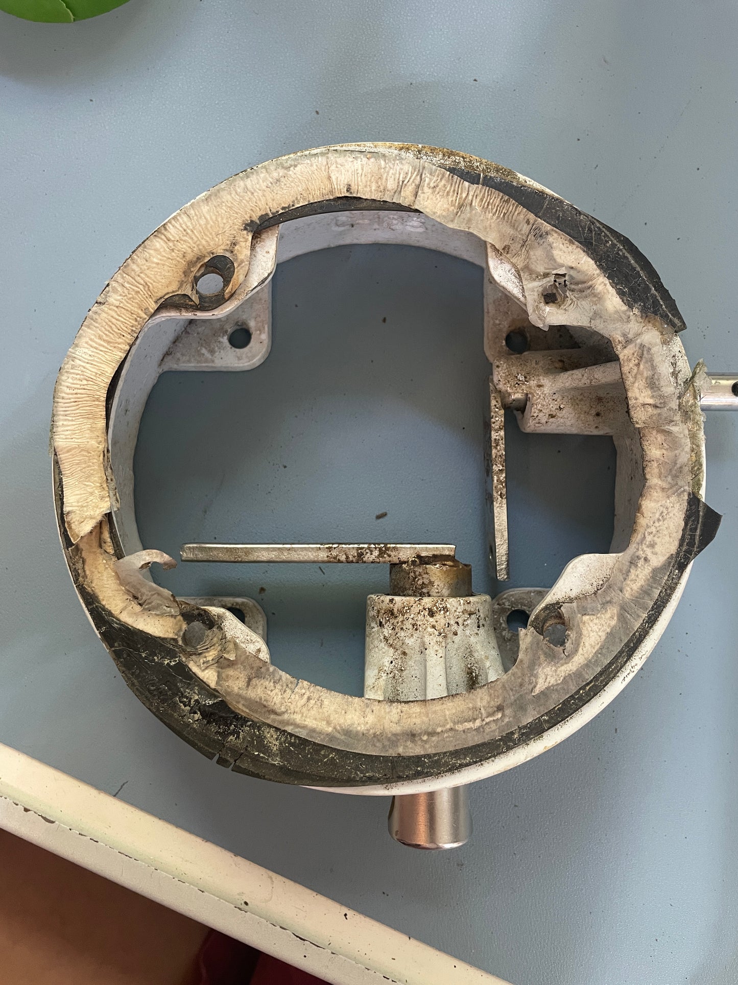 Worn metal component on a gray background