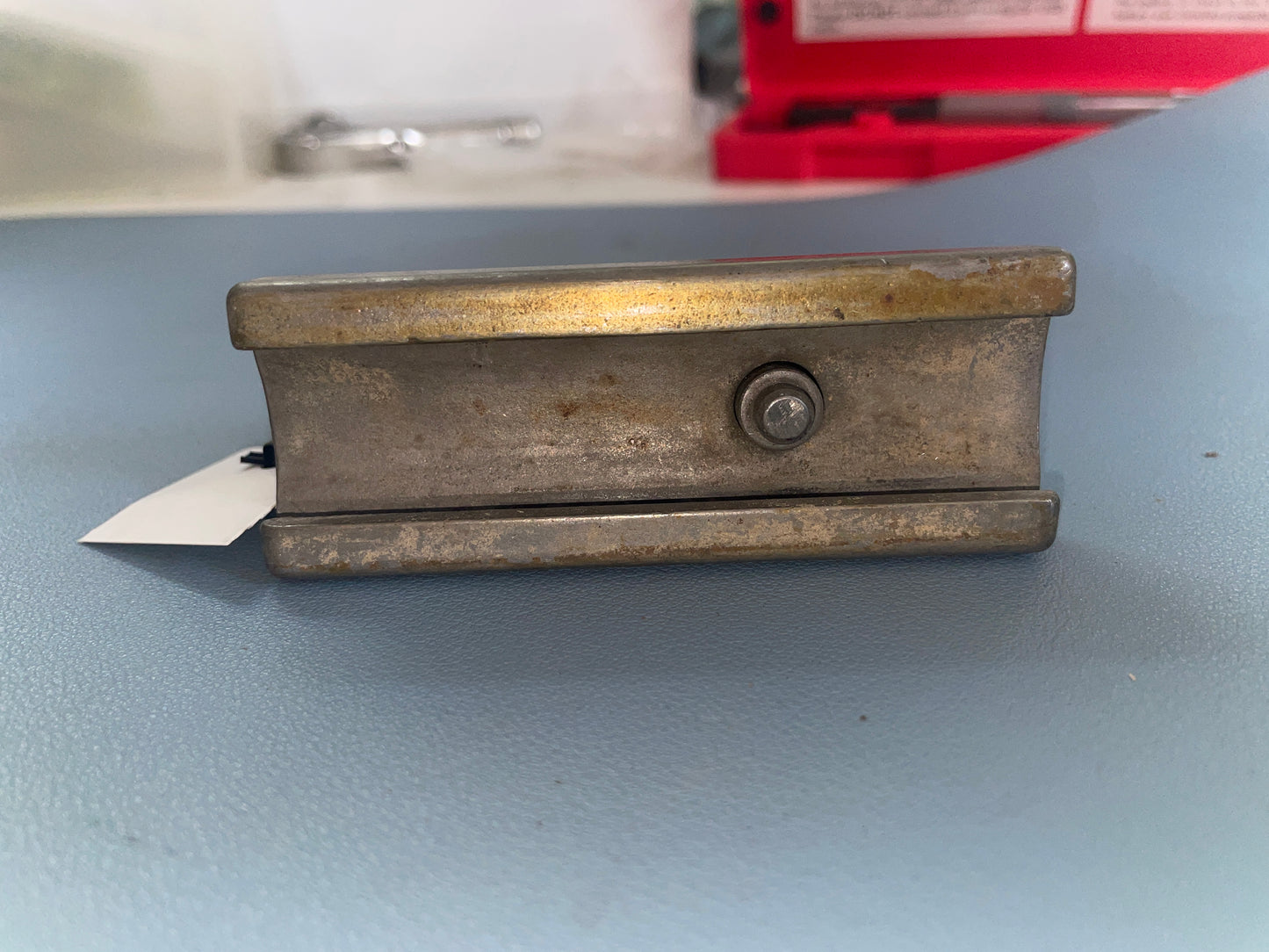 Metallic object with a tag on a gray surface