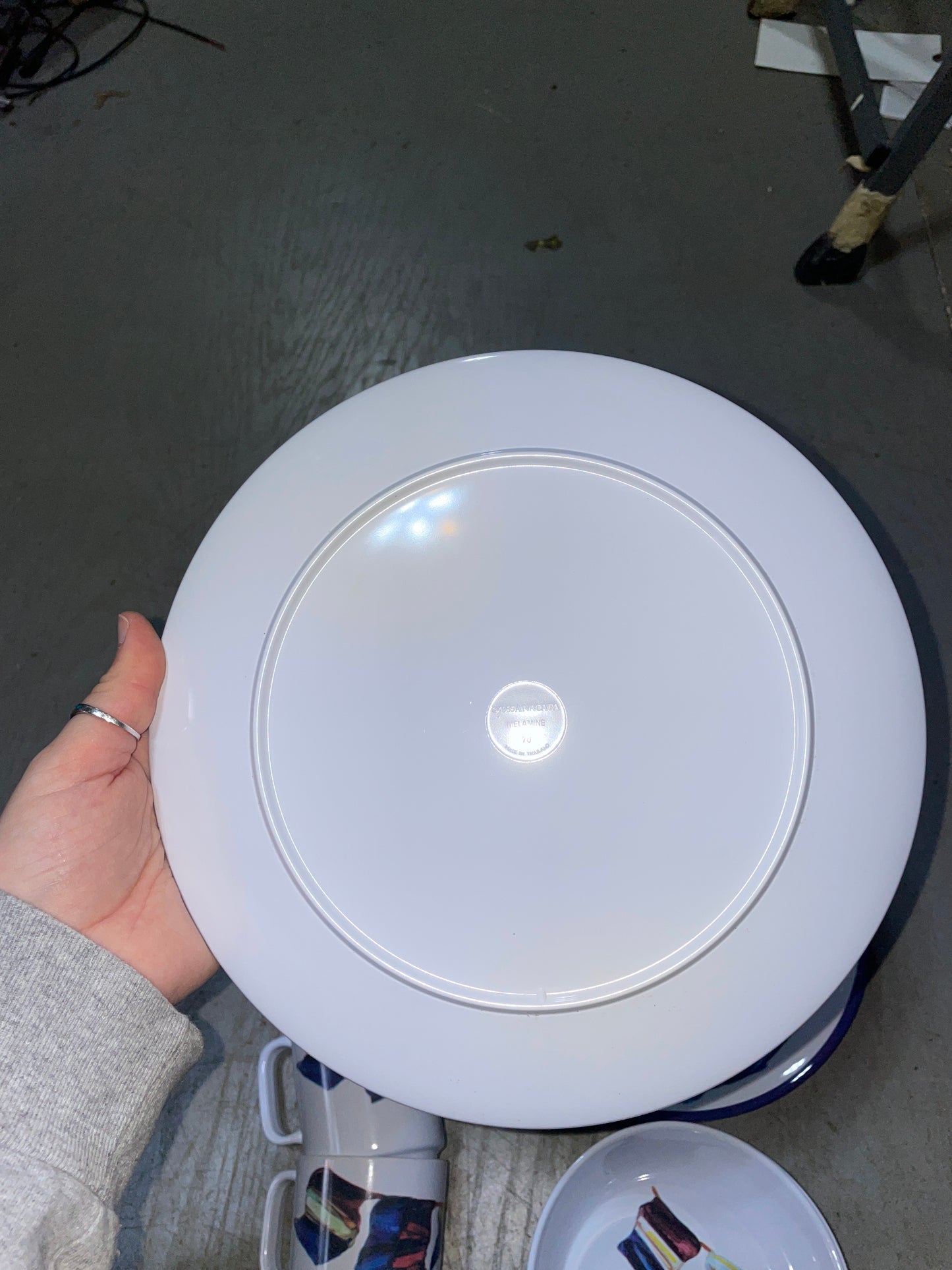 White round object held in a hand on a gray floor
